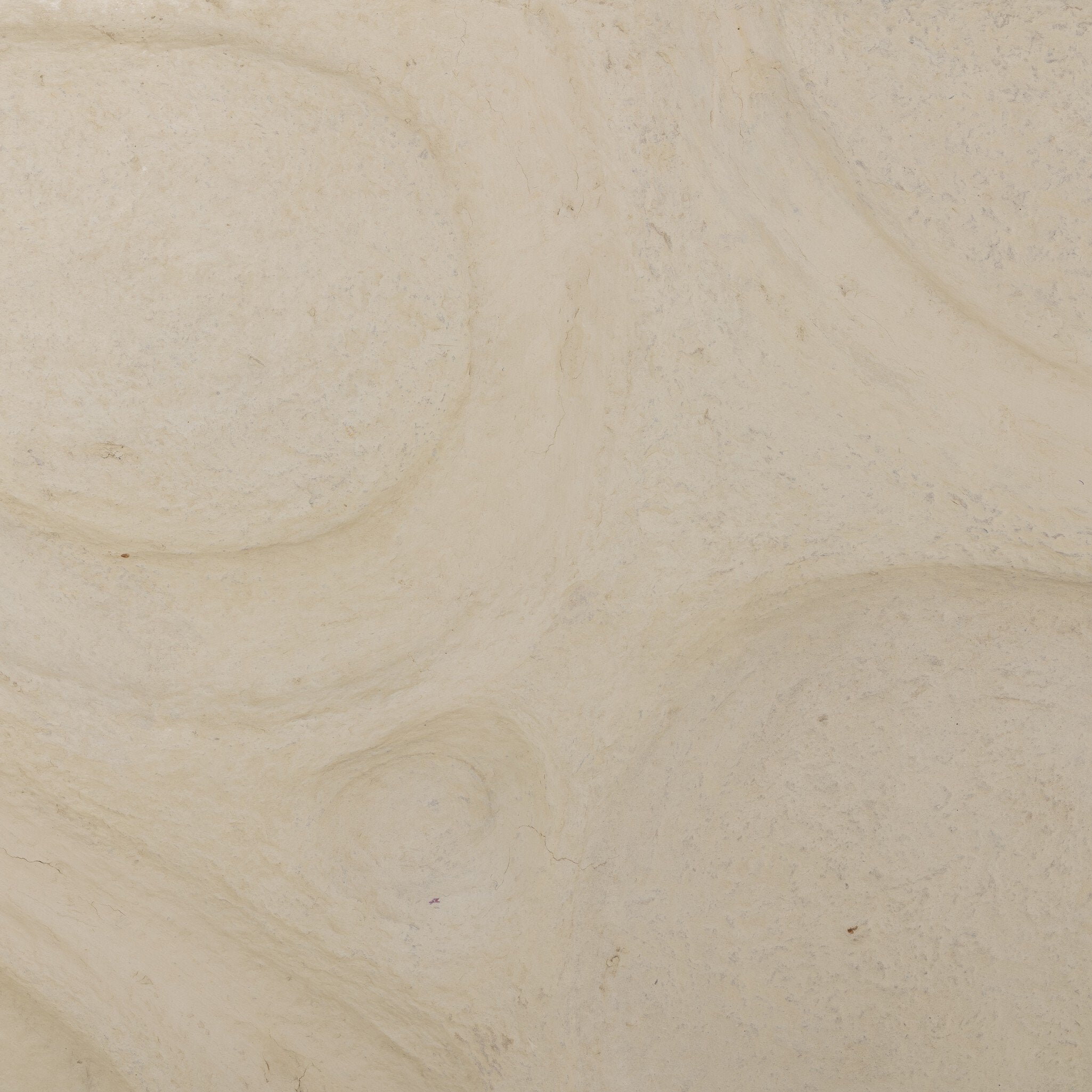 Close-up of beige textured artwork with circular patterns