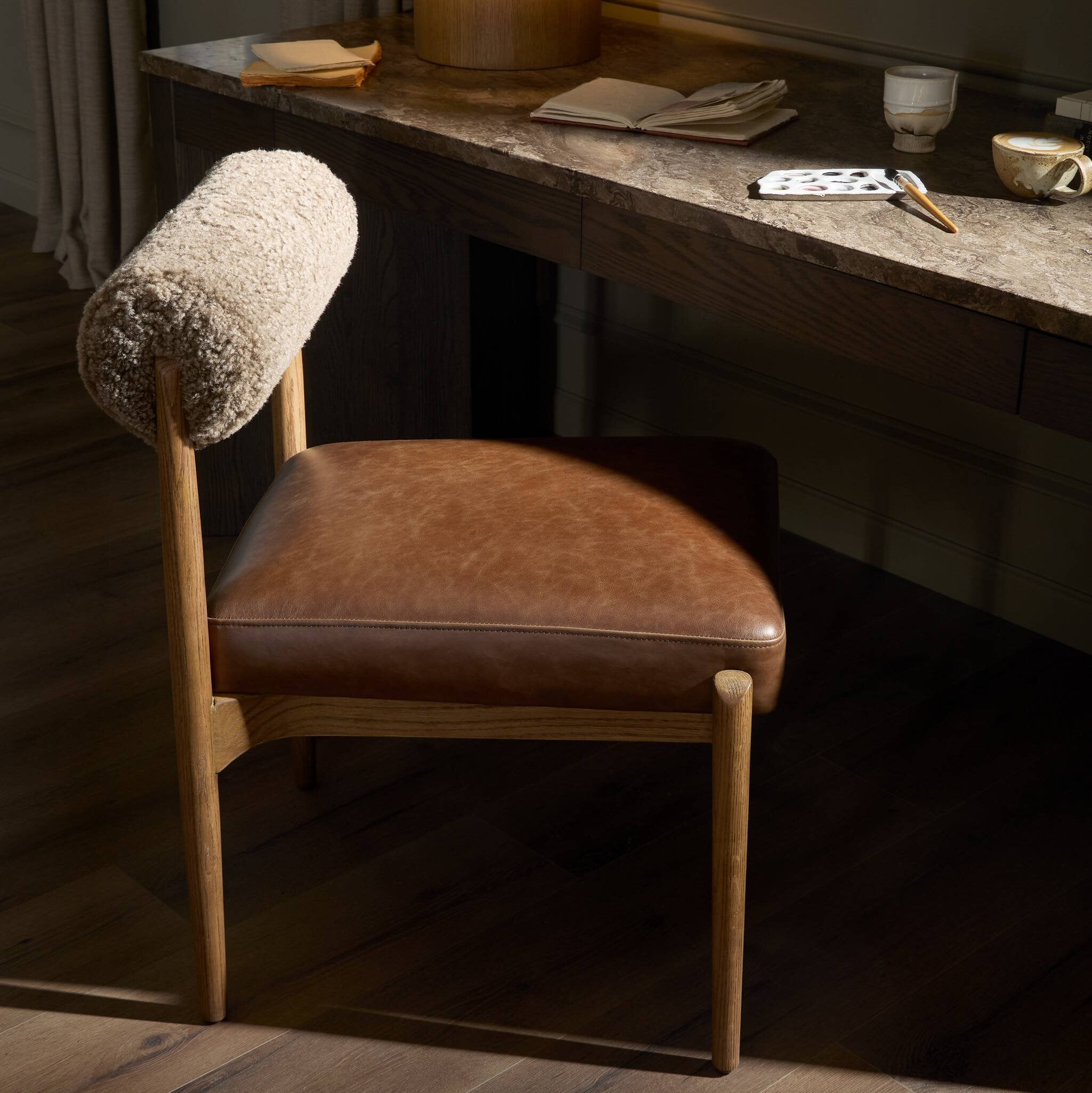 Brown leather chair with a textured backrest in a dimly lit room.
