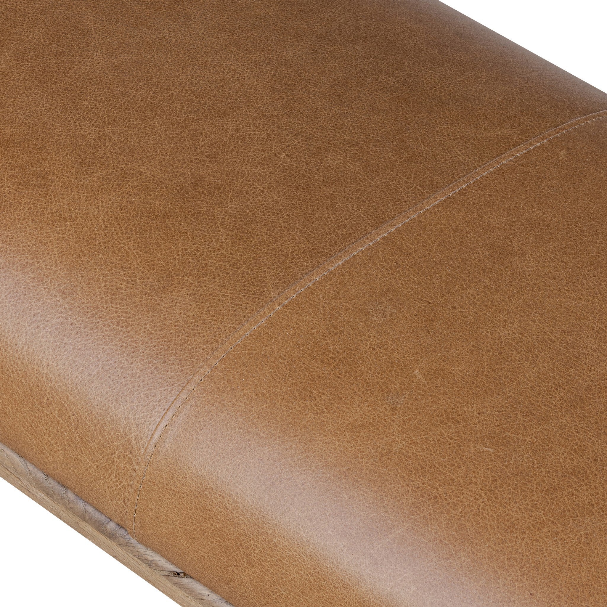 Close-up of a brown leather bench seat with visible texture