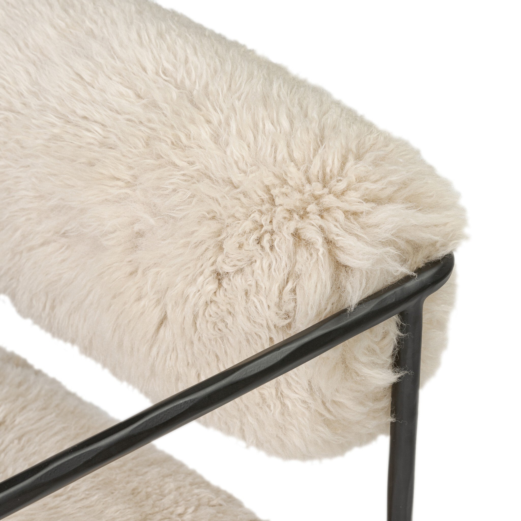 Close-up of a fluffy white cushion on a black metal frame