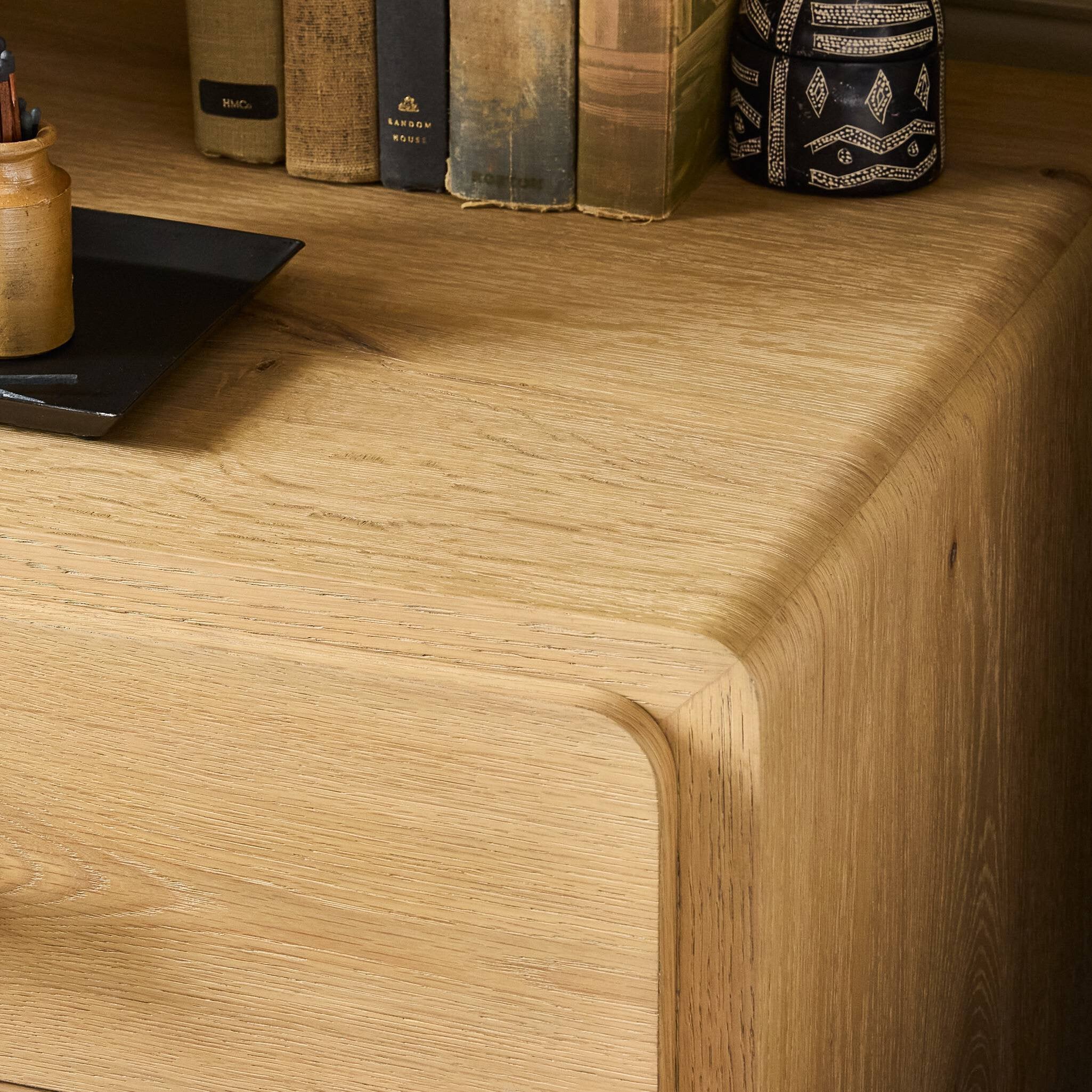 Wooden desk surface with books and a decorative item.