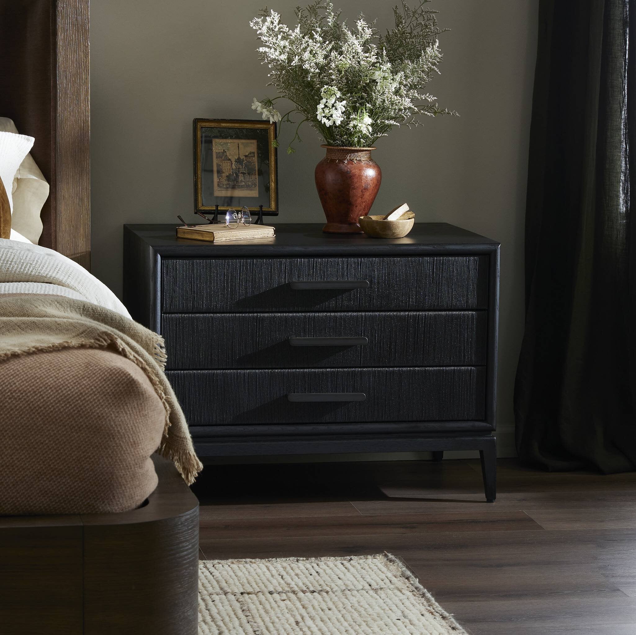 Dark wooden dresser with decorative items in a bedroom setting