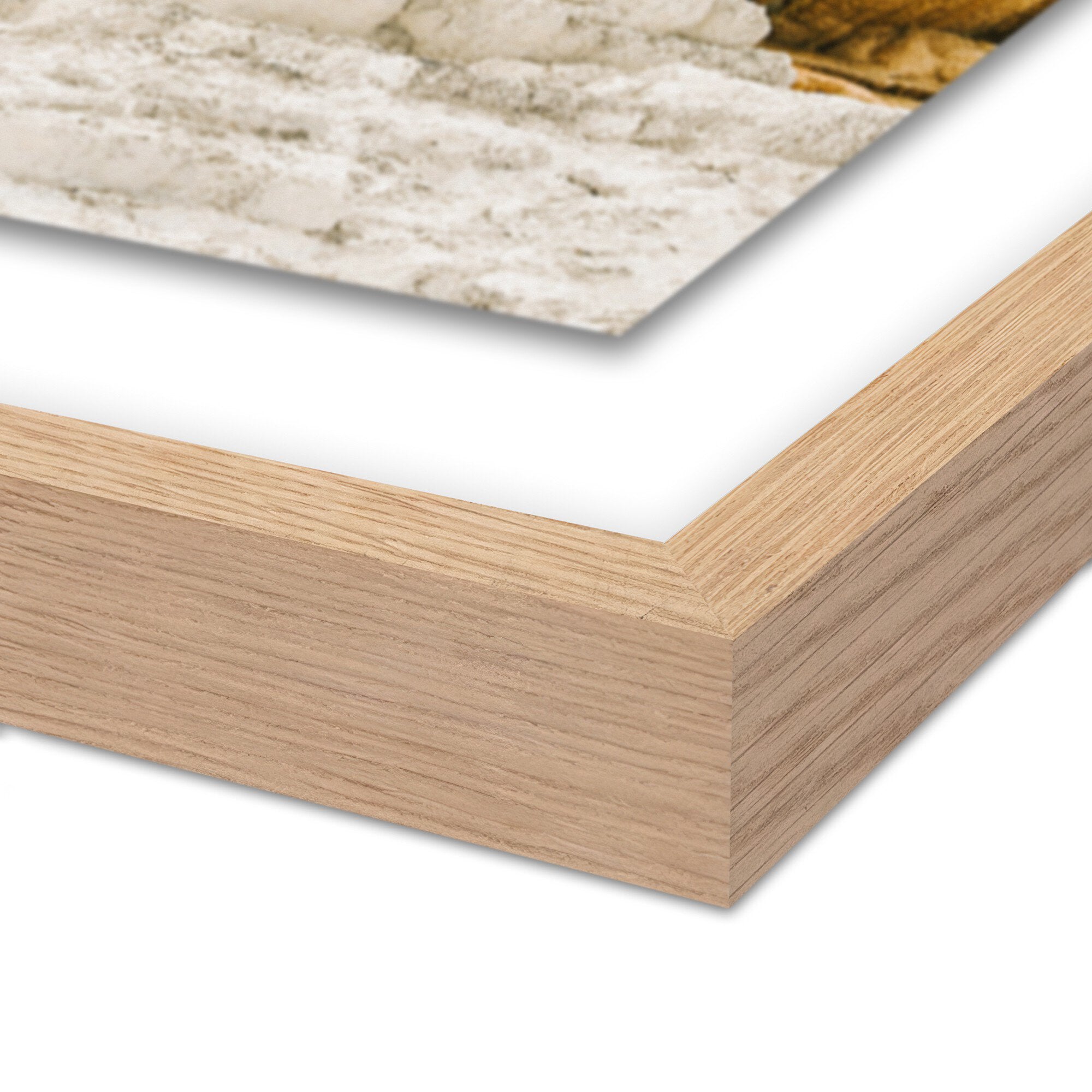 Close-up of a wooden picture frame with a white mat and a blurred background