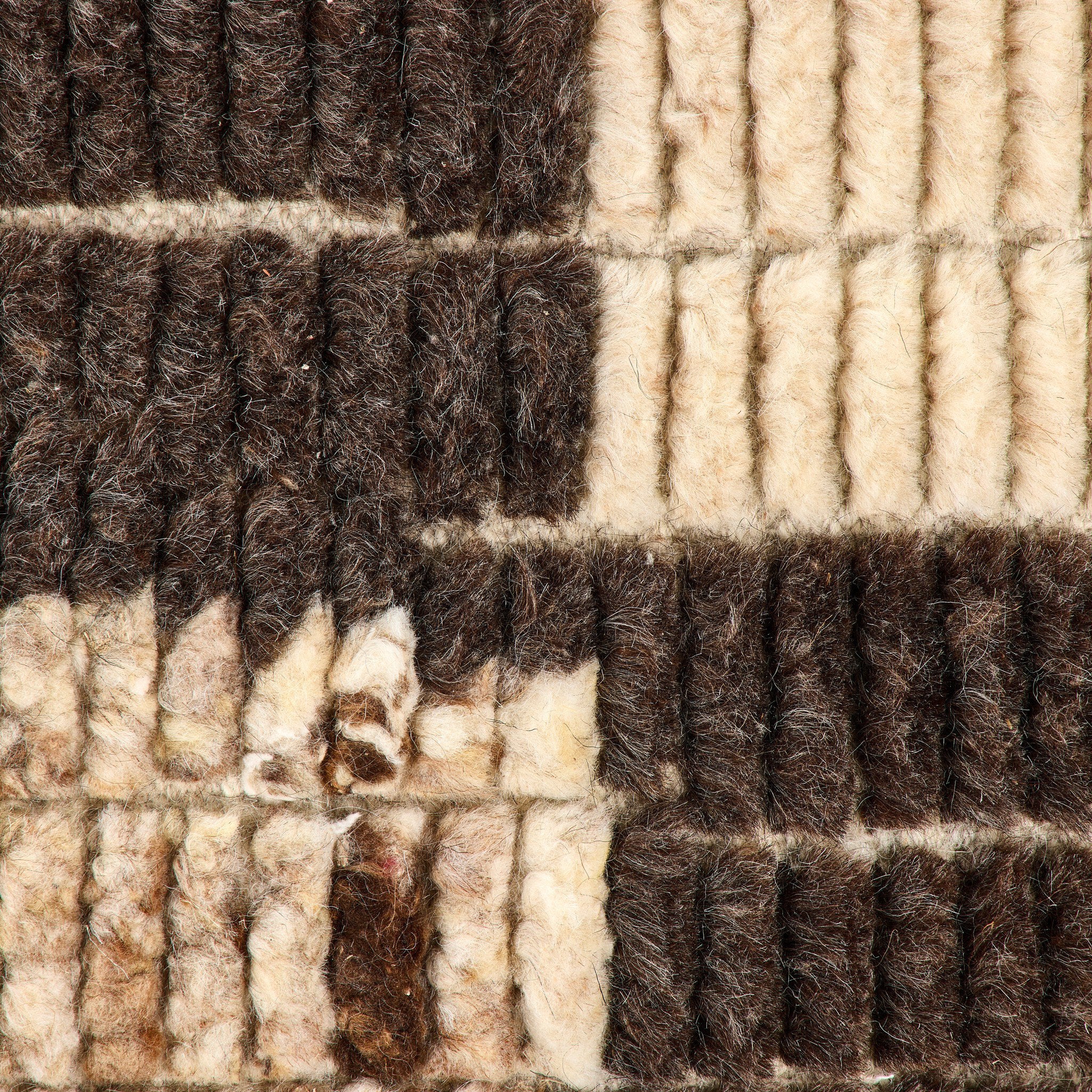 Close-up of a checkered patterned rug with brown and beige colors.