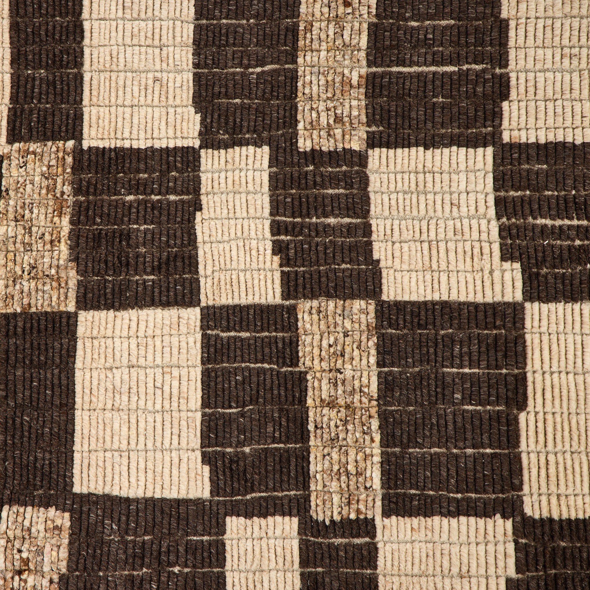 Close-up of a woven pattern with alternating black and beige squares.