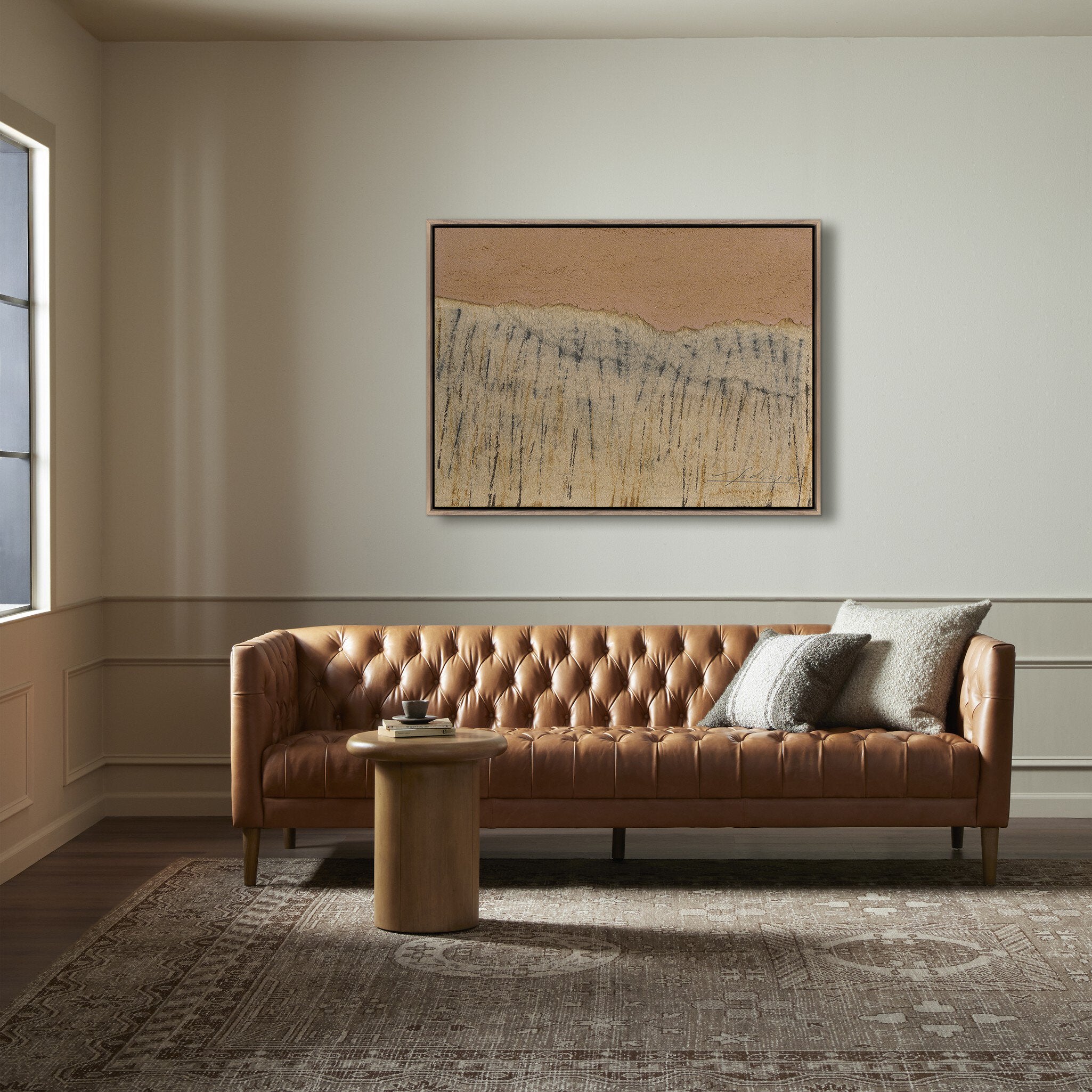Brown leather sofa in a living room with abstract art on the wall.