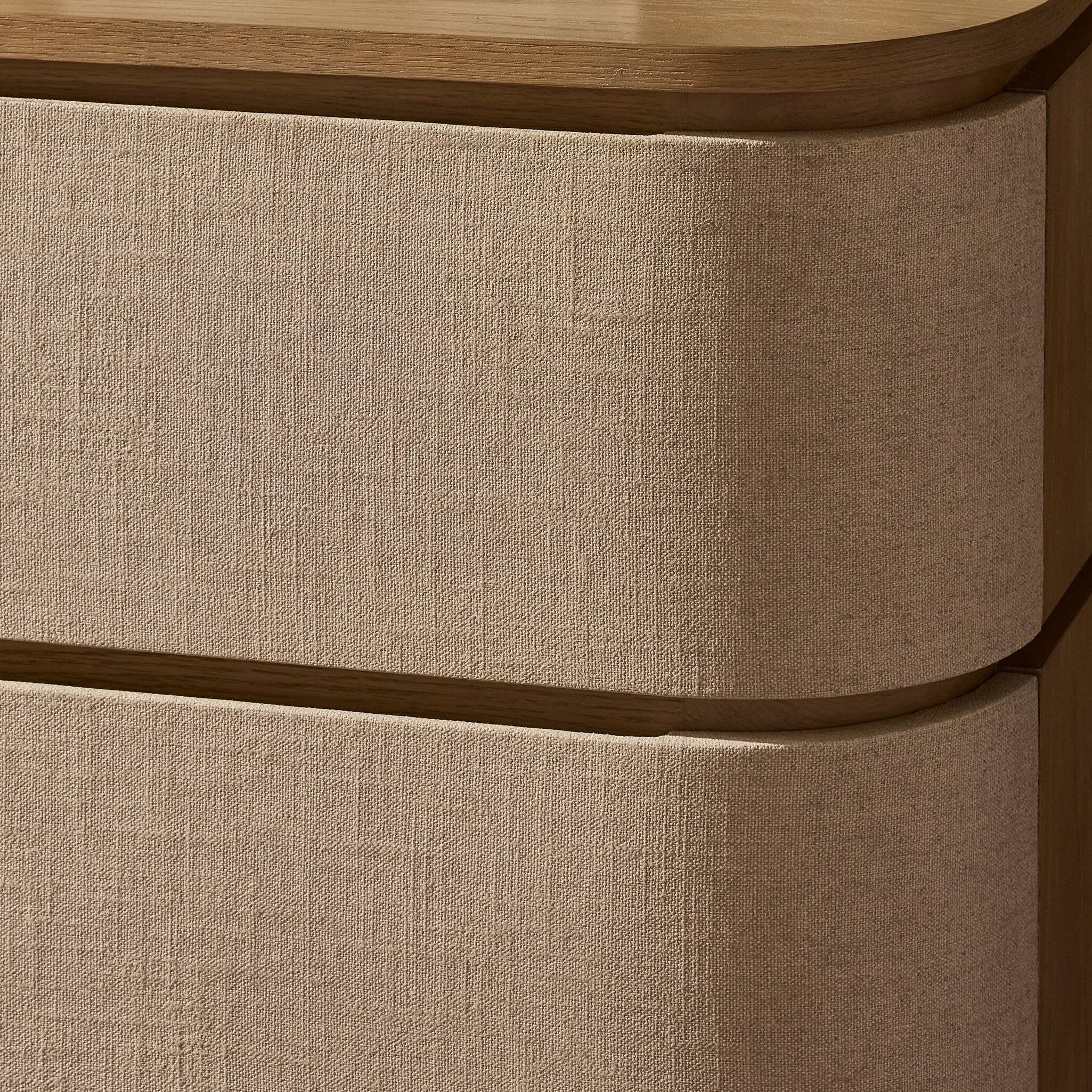 Close-up of a textured linen beige drawer with wooden edges.