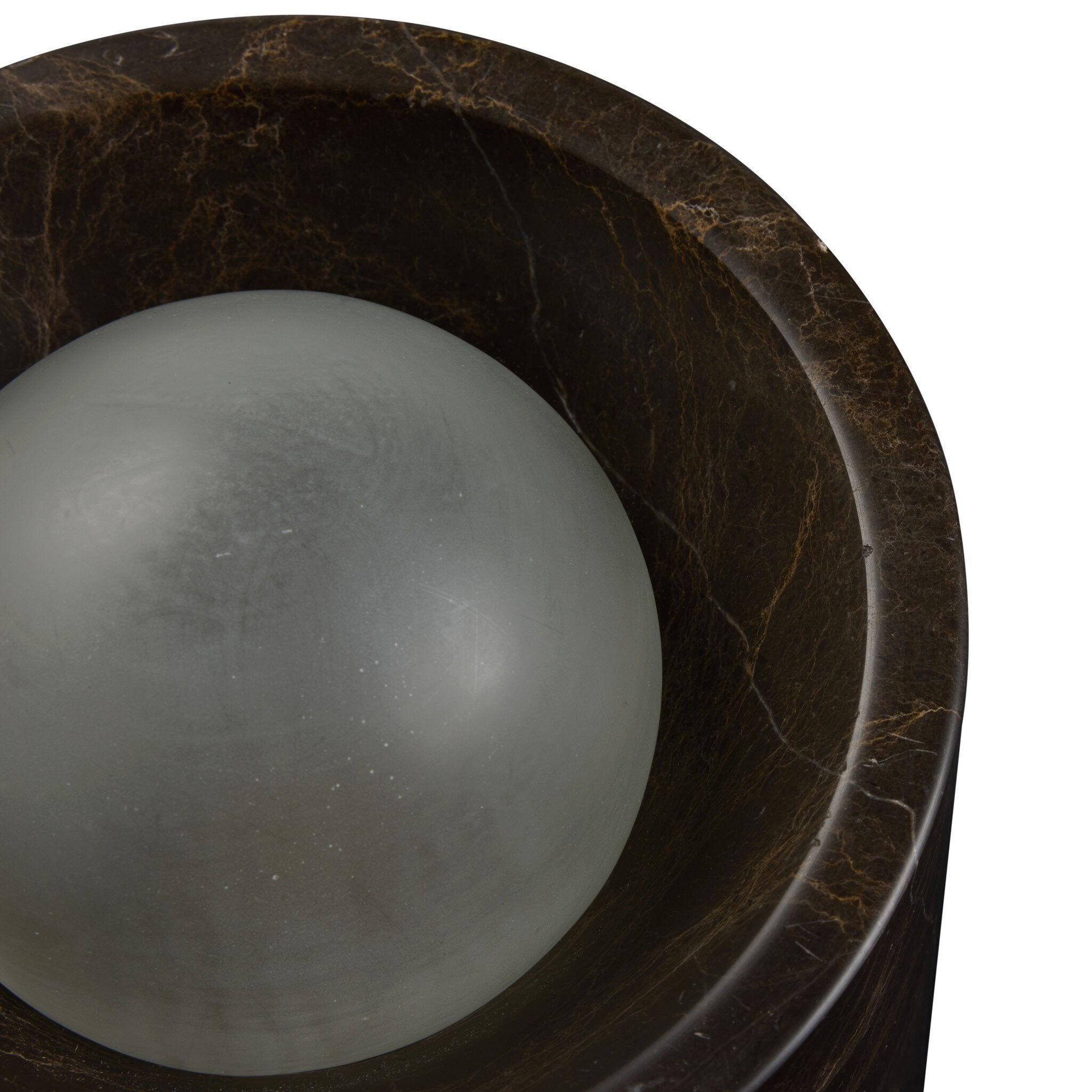 Gray sphere inside a dark brown marble basin on a white background