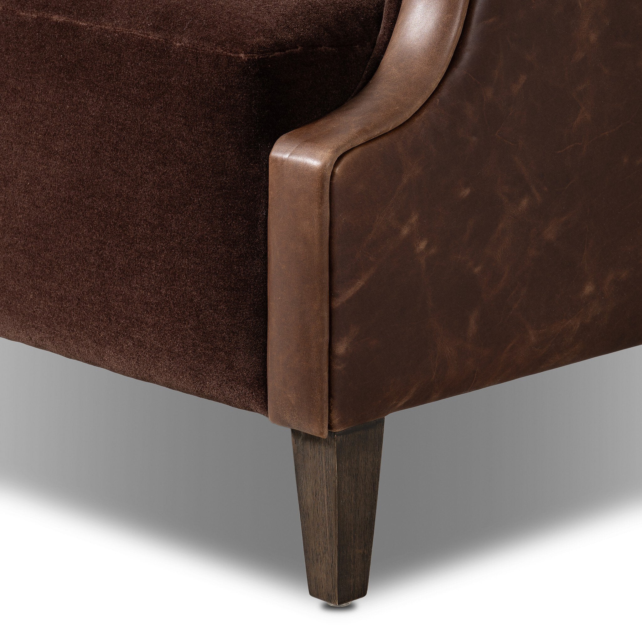Close-up of a brown leather armchair corner on a white background
