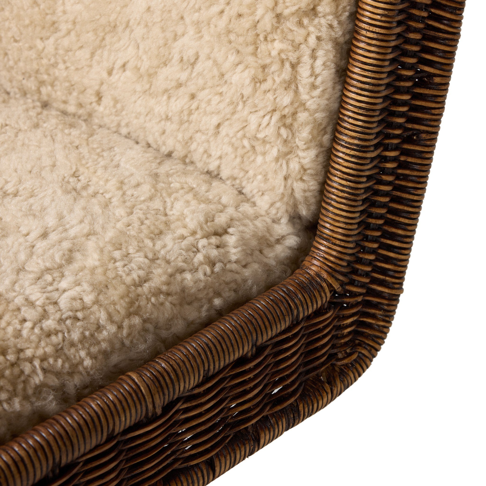 Close-up of a textured shearling cusion with wicker frame