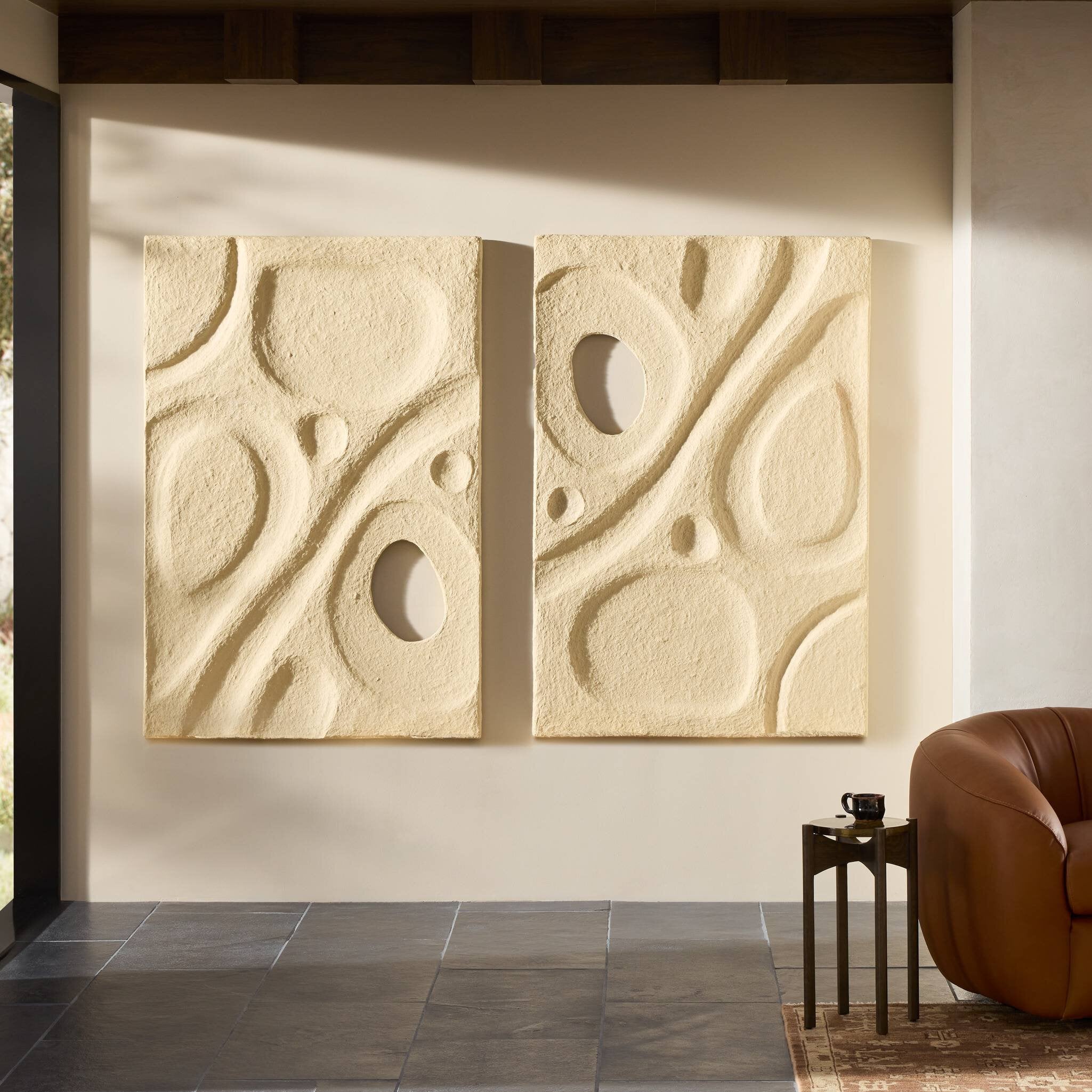 Decorative wall panels with textured patterns in a room with a brown chair and small table.