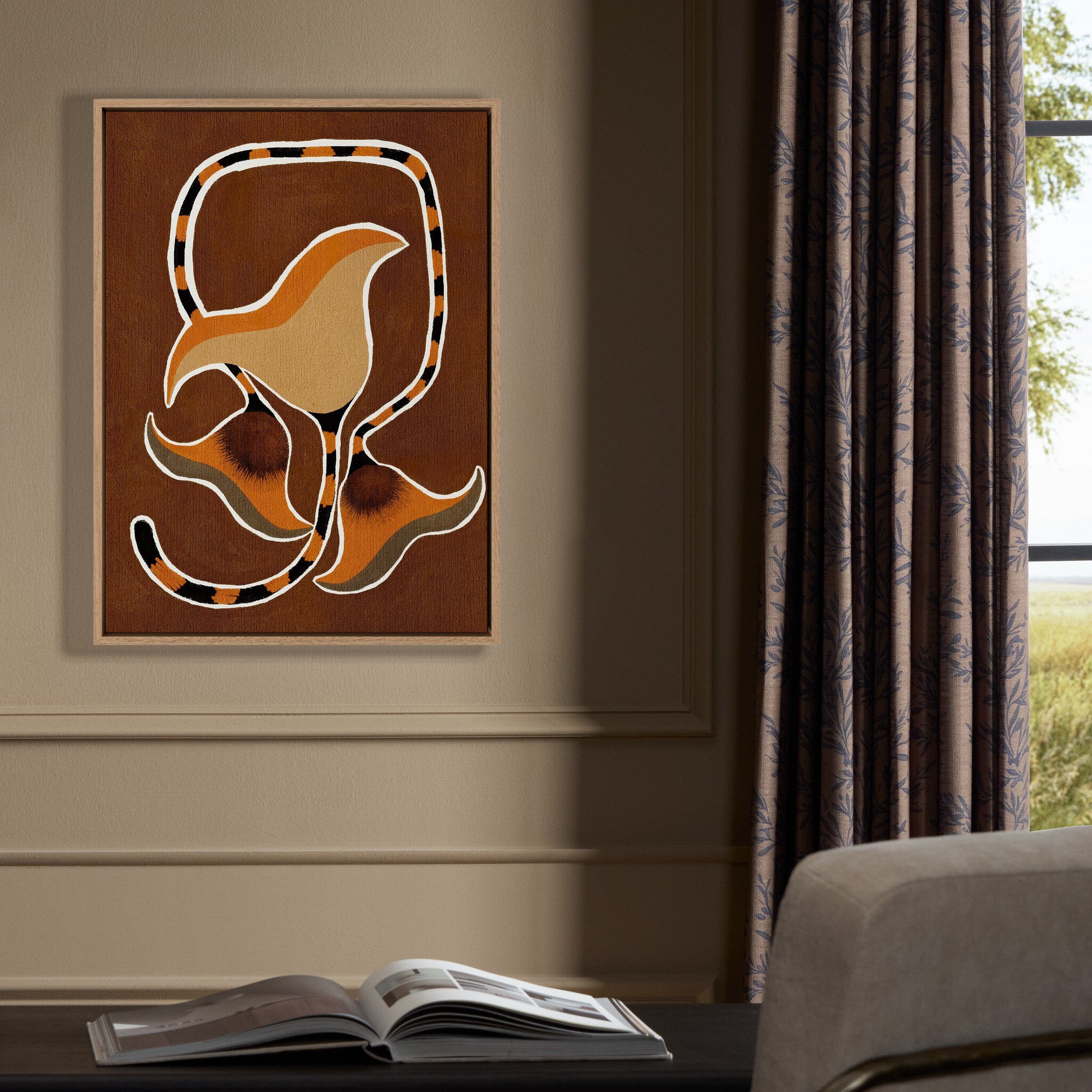 Abstract art piece on a wall with an open book on a surface below.