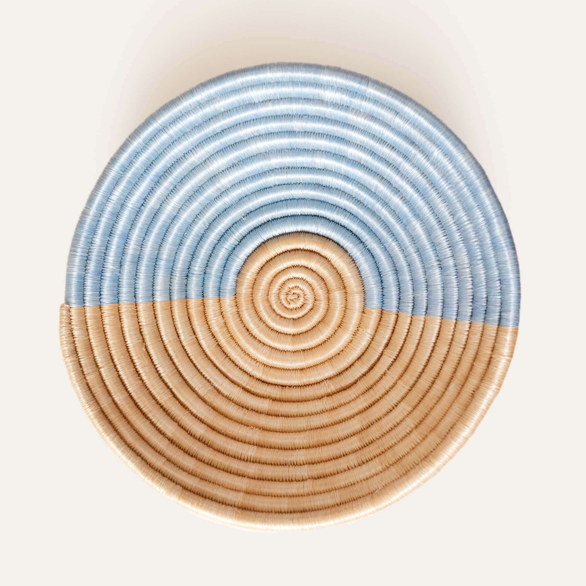 Round woven basket with blue top and brown bottom on a white background