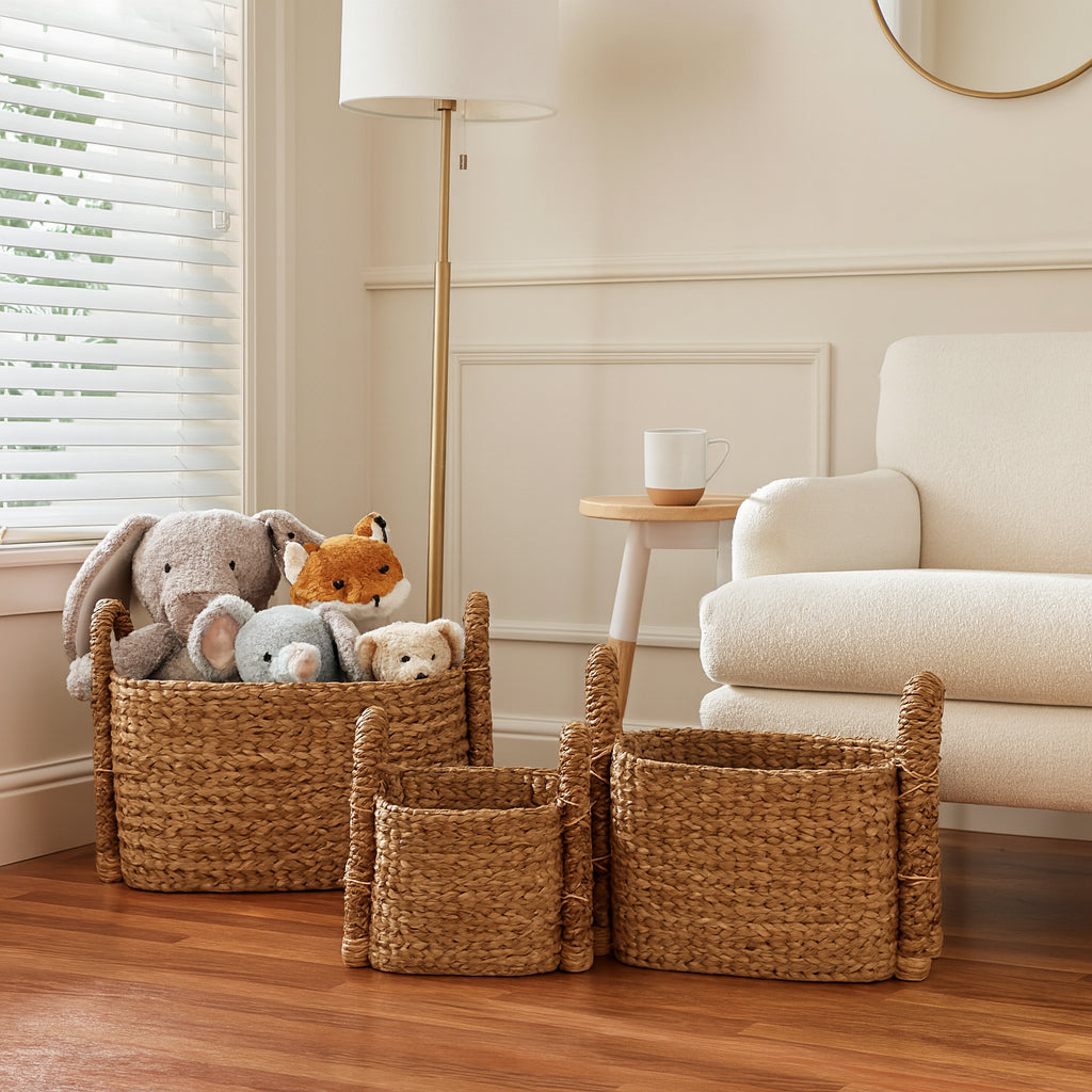 Woven baskets with stuffed animals on a wooden floor in a living room.