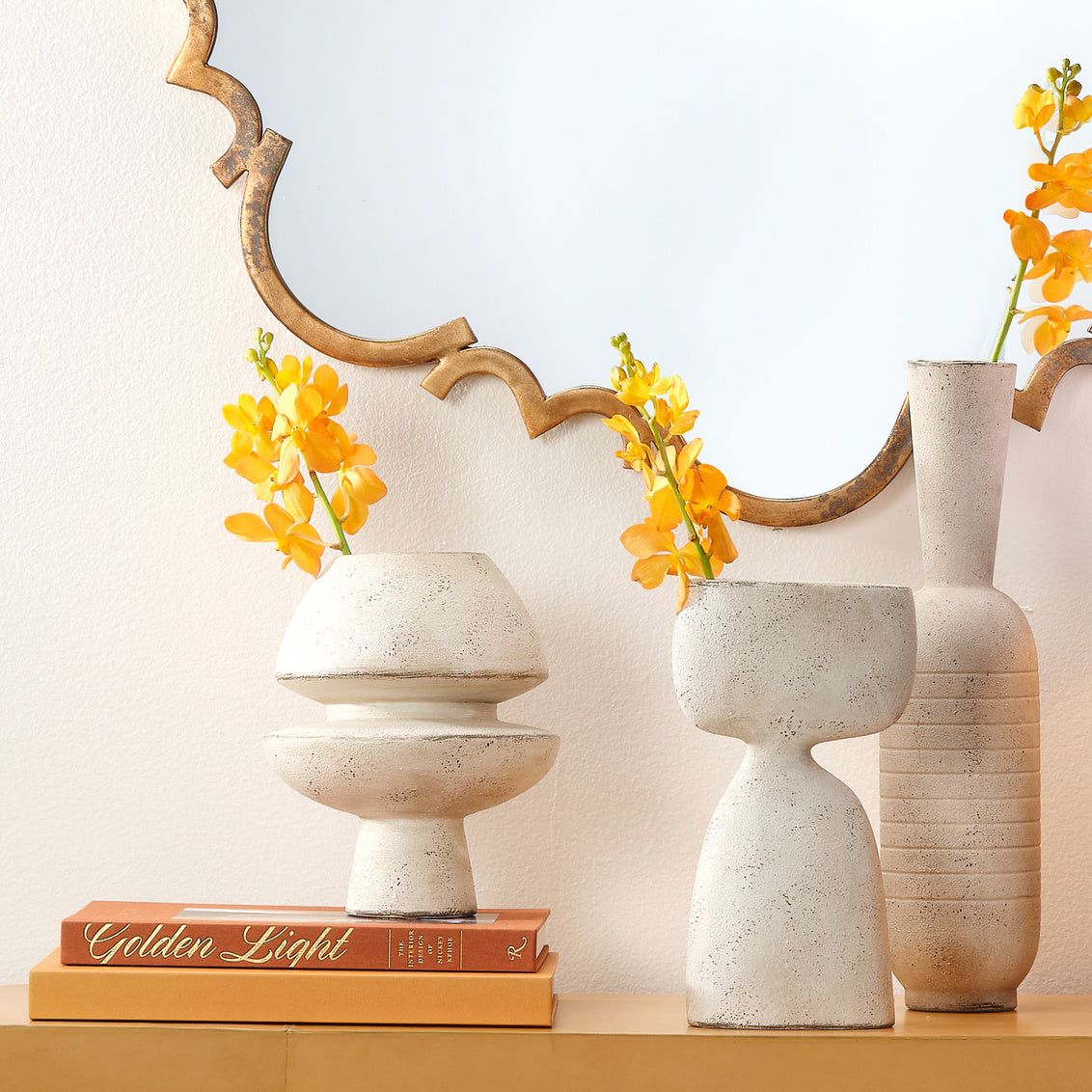 Decorative vases with yellow flowers on a shelf against a light background
