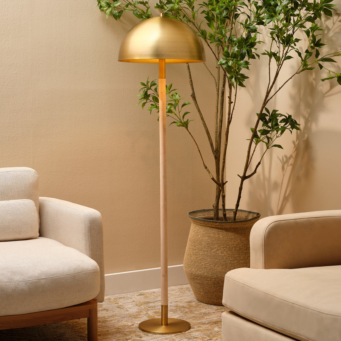 Gold floor lamp in a living room setting with beige walls and furniture.