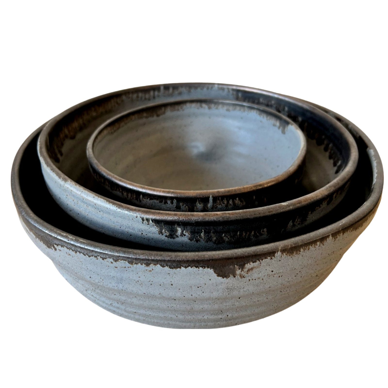 Set of three ceramic bowls with a rustic finish on a white background