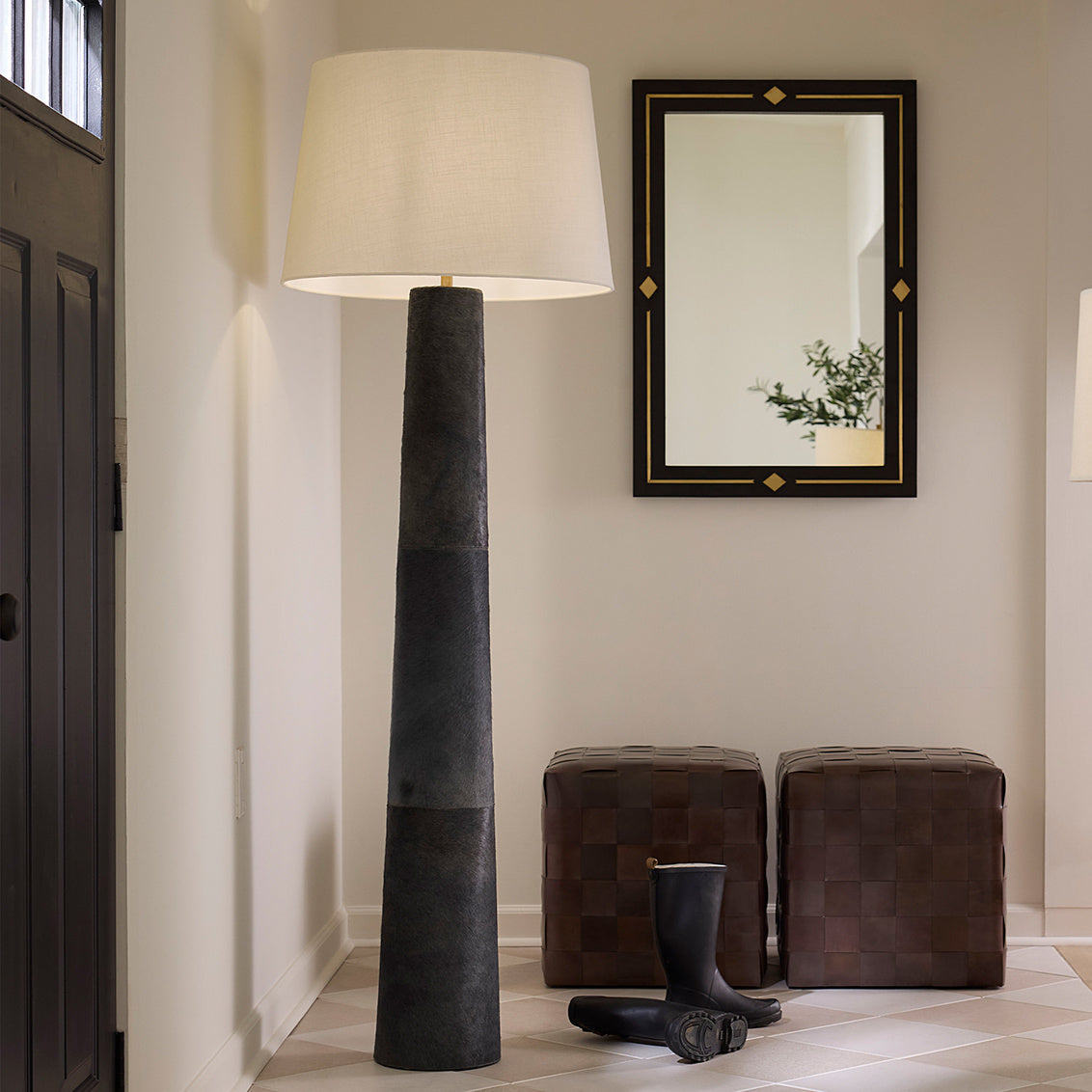 Foyer with a tall floor lamp, mirror, and footstools.