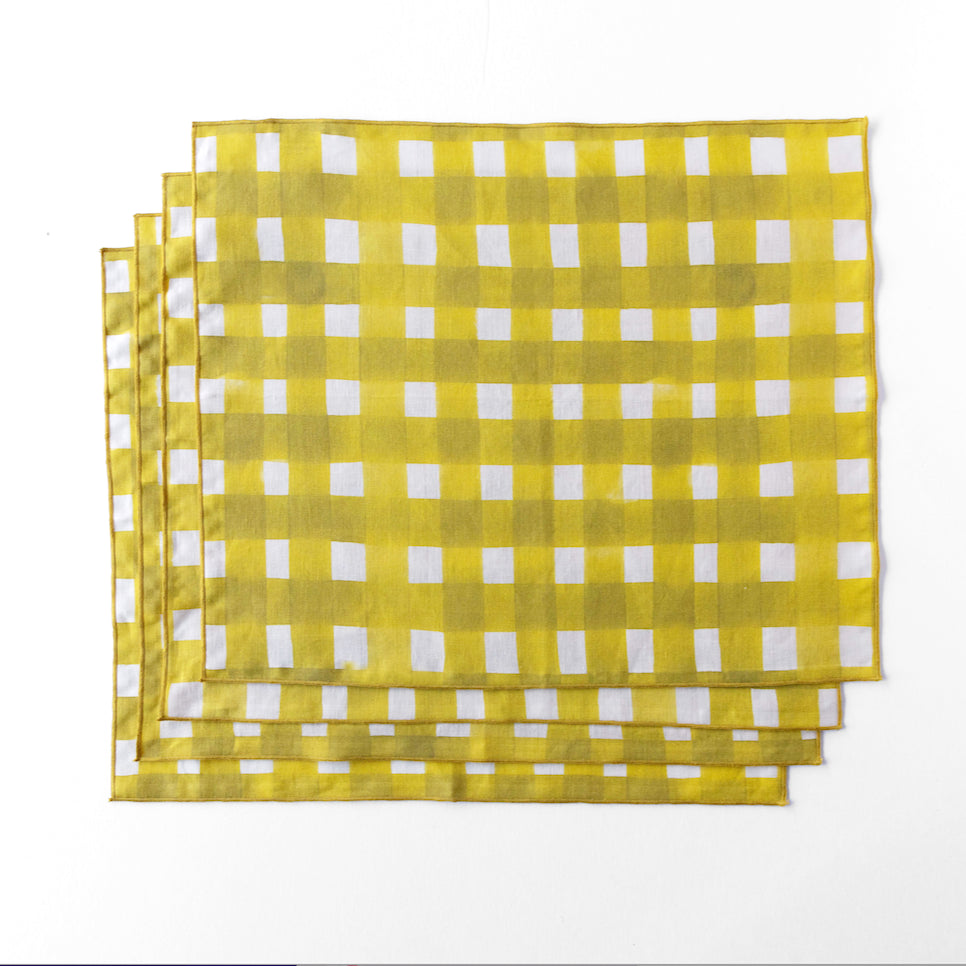 Yellow and white checkered placemats on a white background