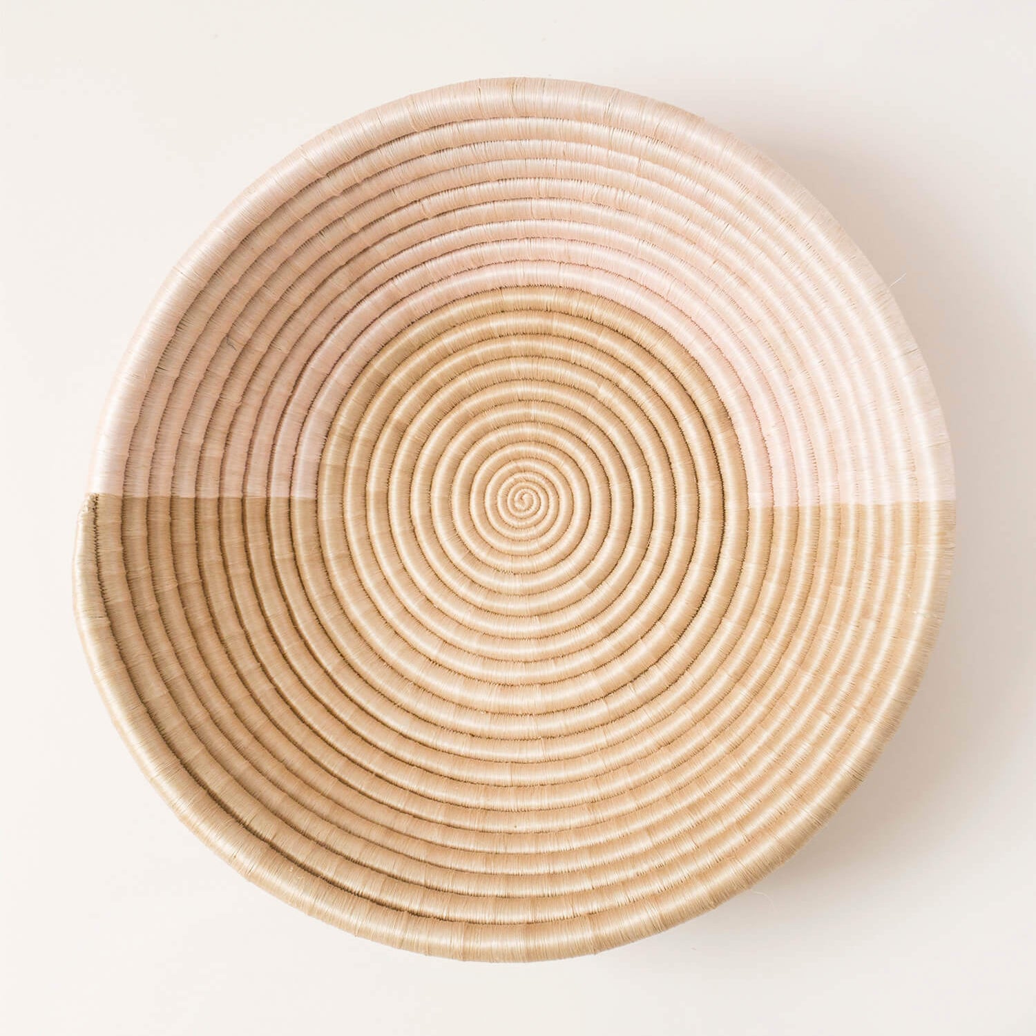Woven basket with concentric circle pattern on a white background
