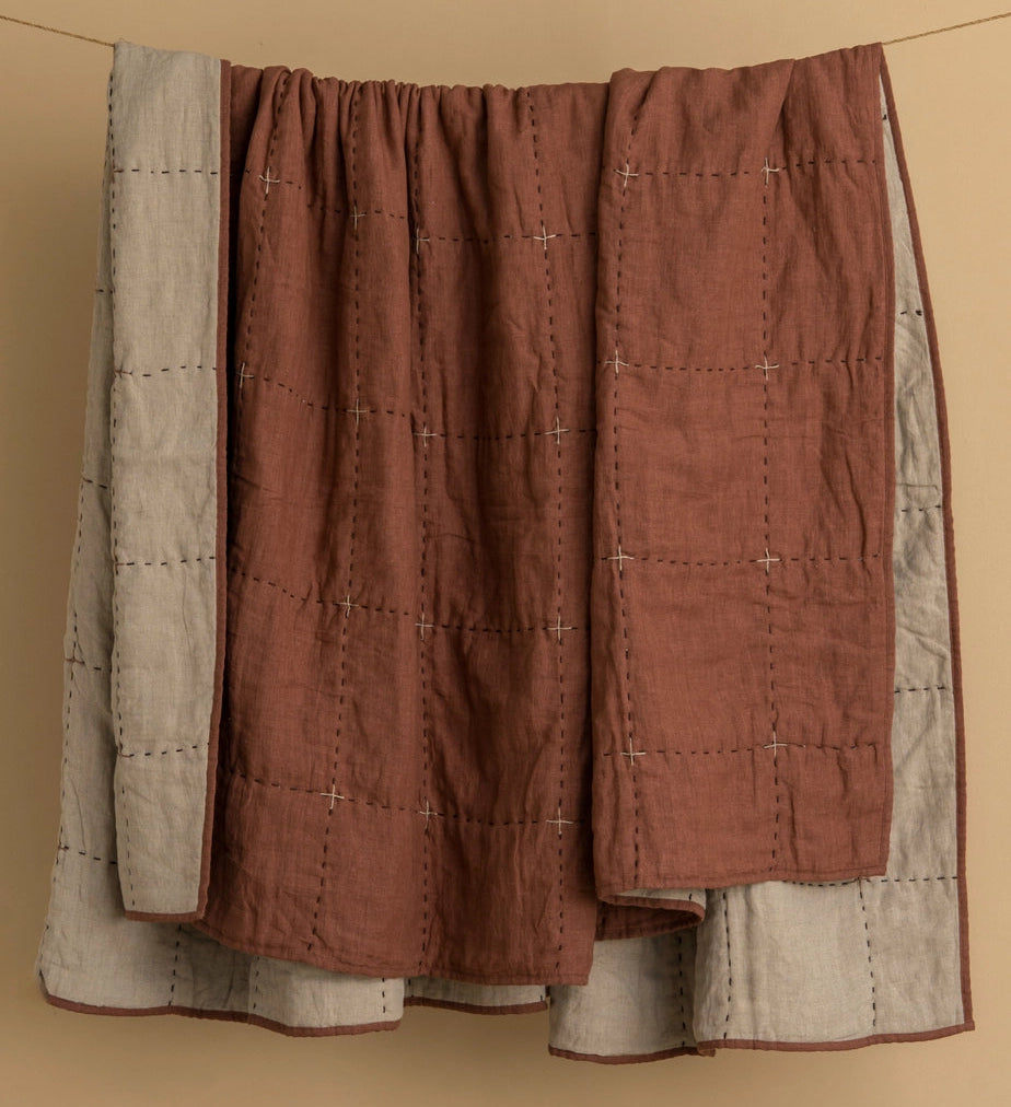 Quilted fabric piece with brown and beige pattern on a beige background