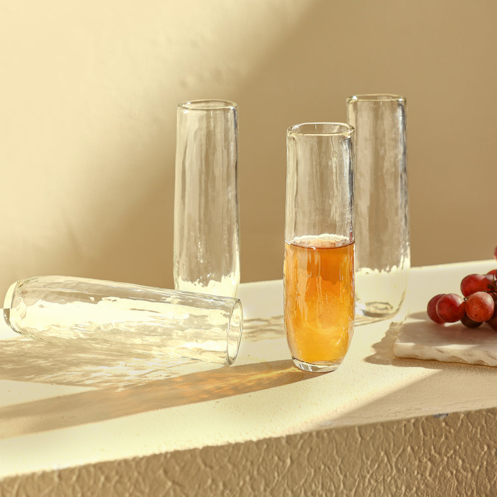 Clear glass with amber liquid on a light surface with grapes