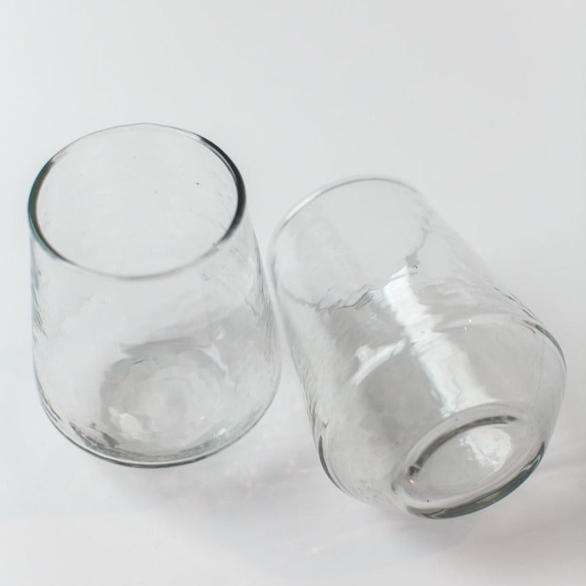 Two clear glass tumblers on a white background