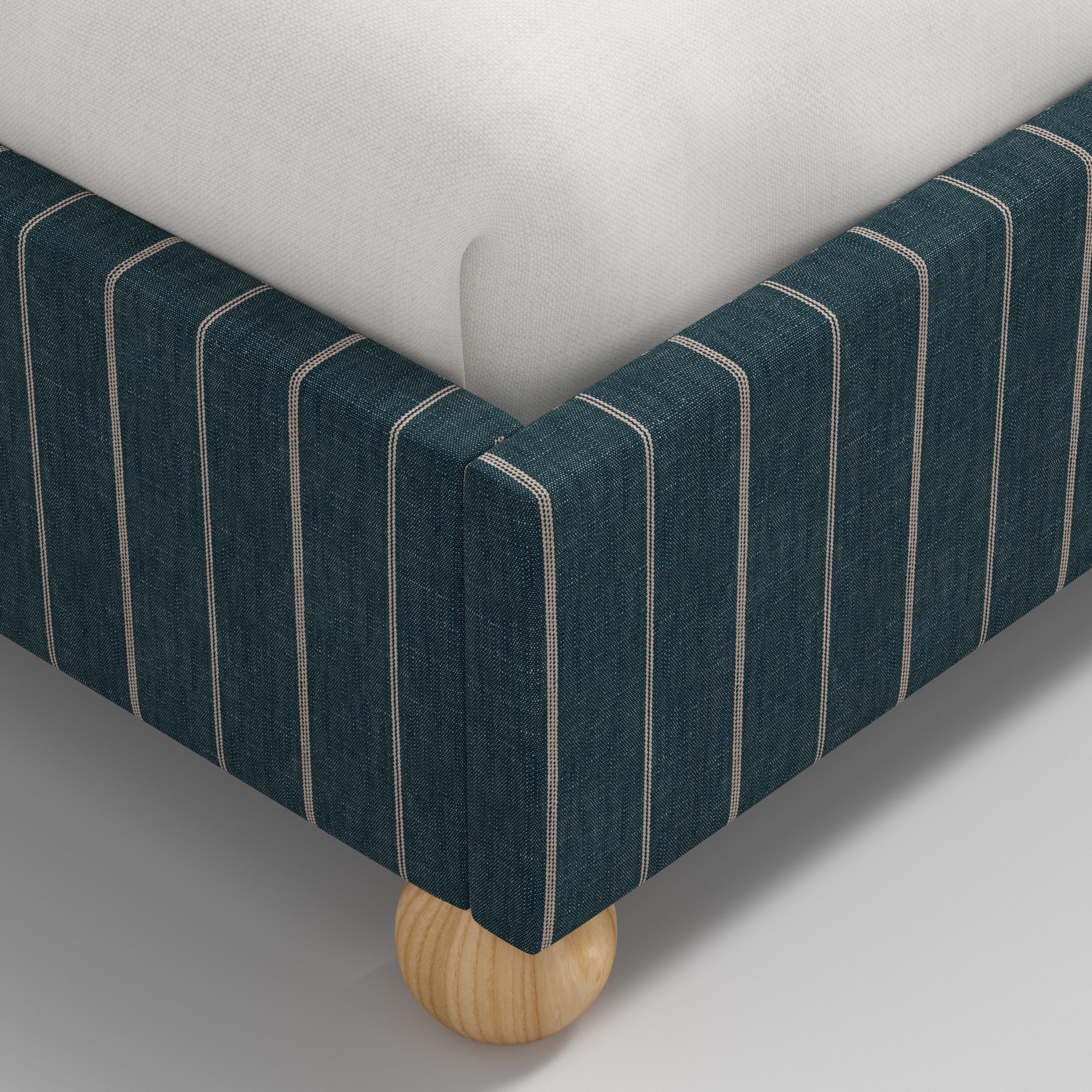 Bed with white bedding and a striped headboard on a white background