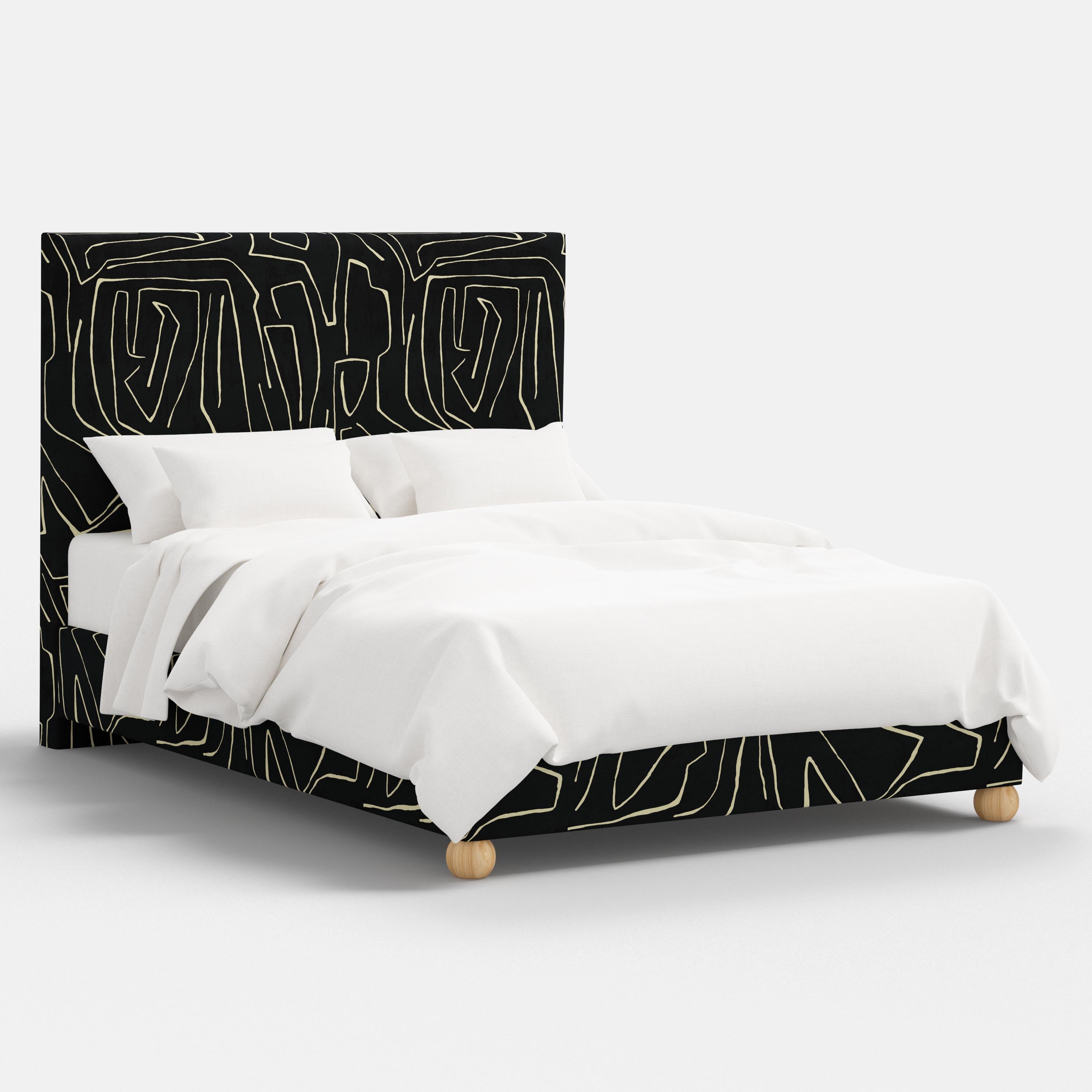 Bed with black and white abstract headboard and bedding on a white background