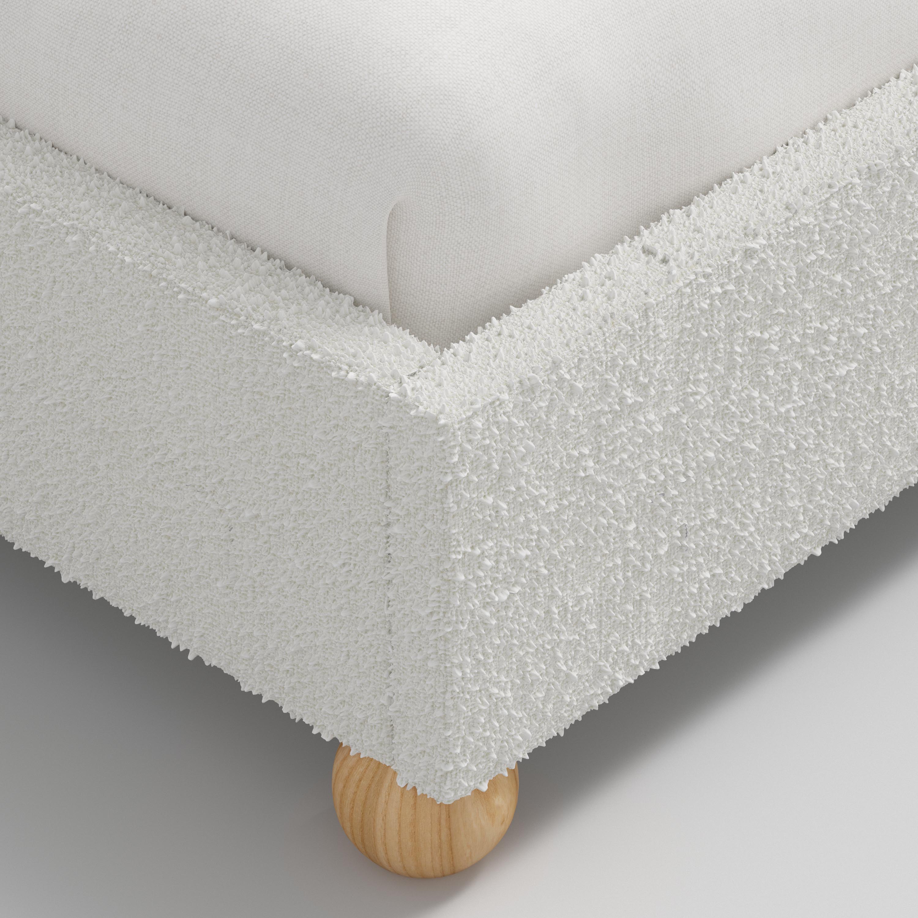 White upholstered bed with wooden legs on a white background