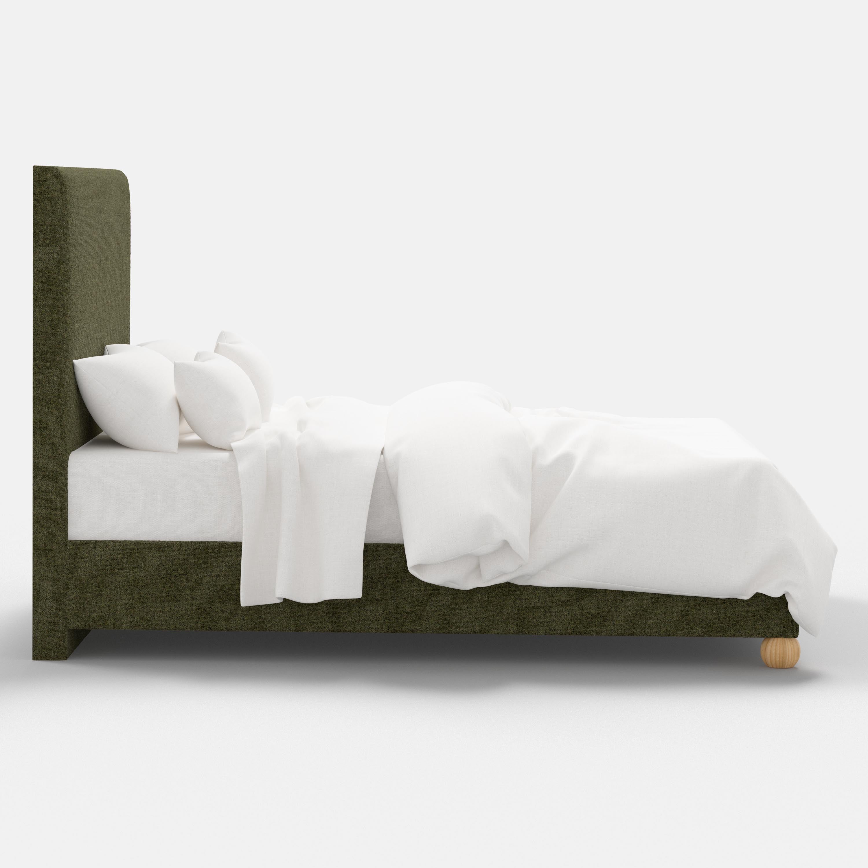 Bed with green upholstered headboard and white bedding on a white background