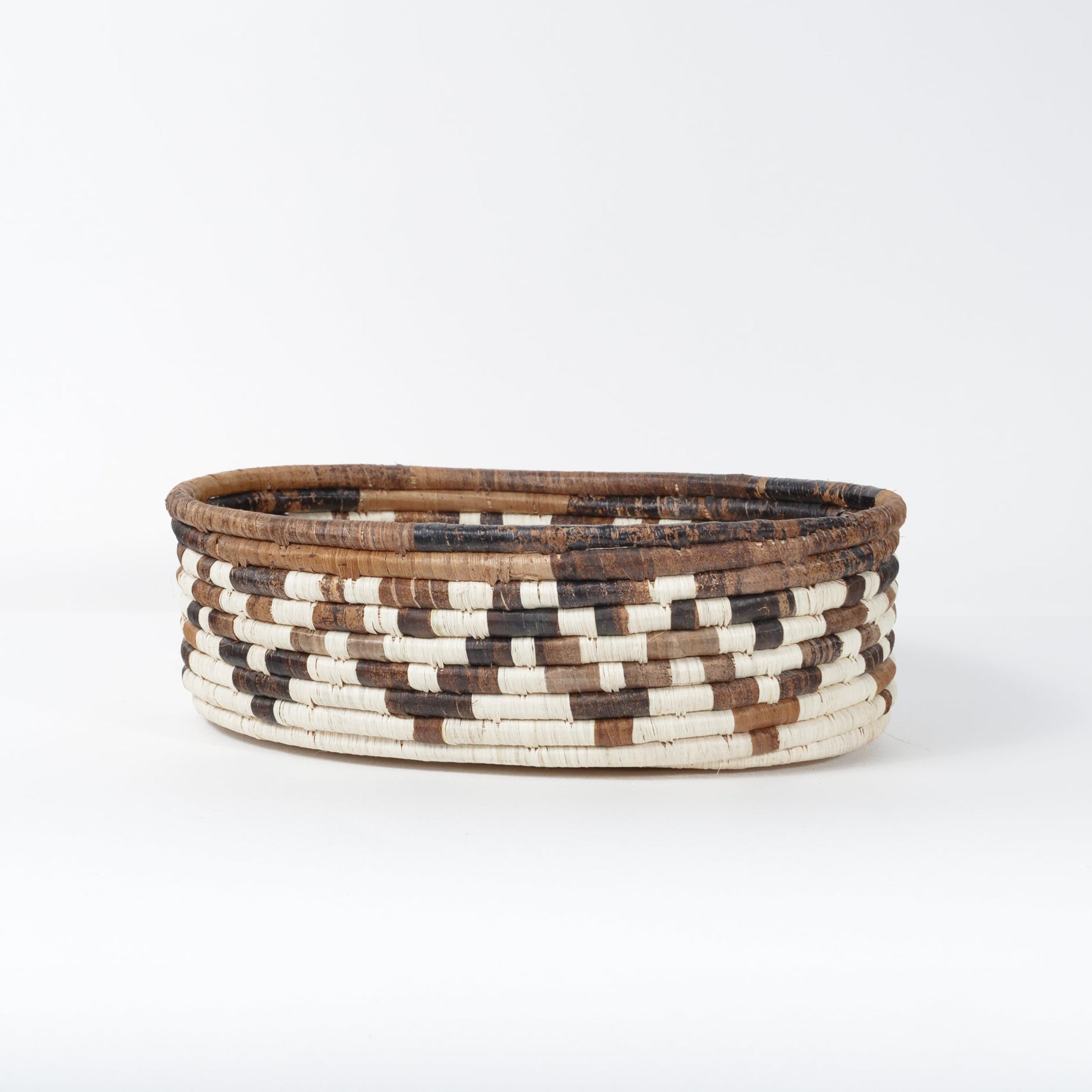 Woven basket with brown and beige pattern on a white background