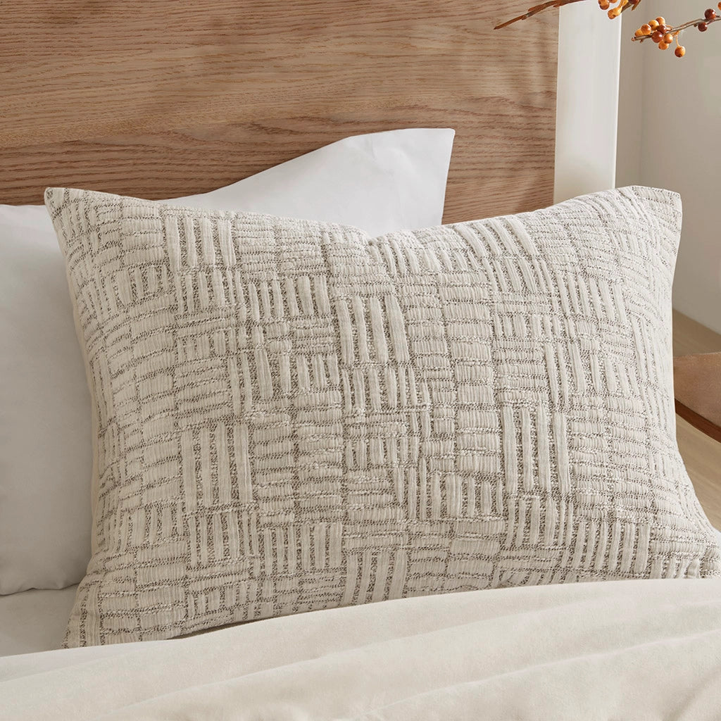 Textured pillow on a bed with a wooden headboard