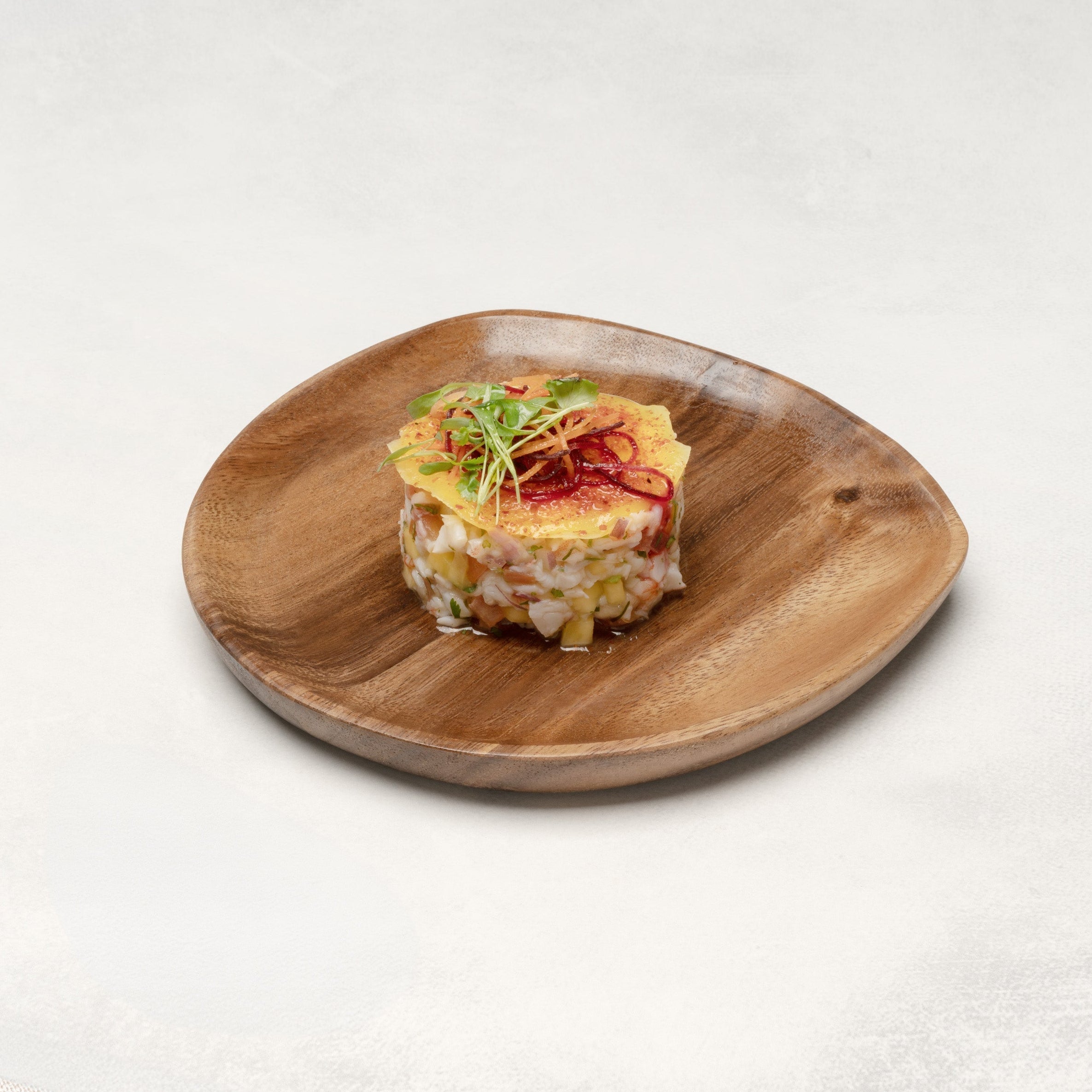 Small appetizer on a wooden plate with a white background