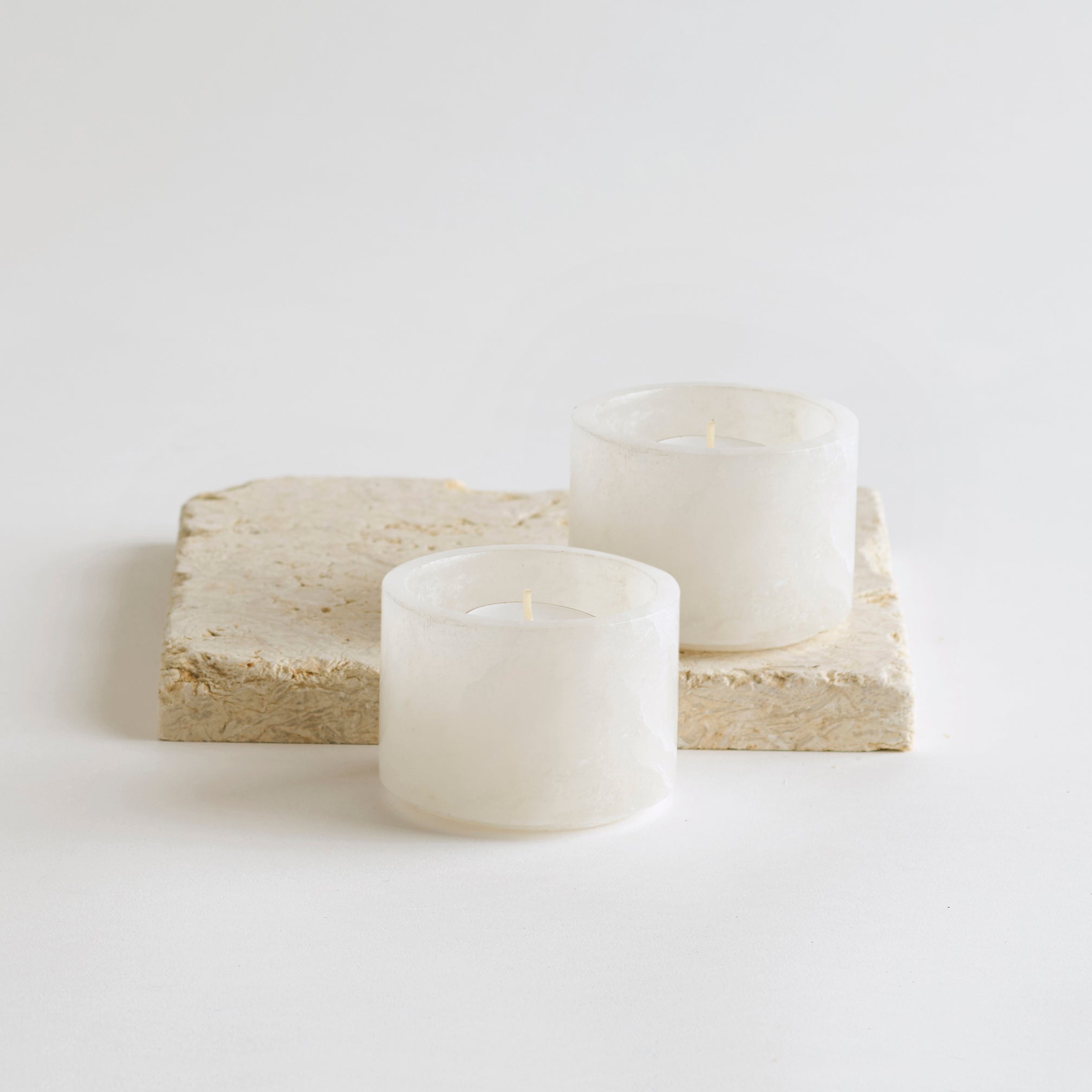 Two alabaster stone bowls that serve as candle holders