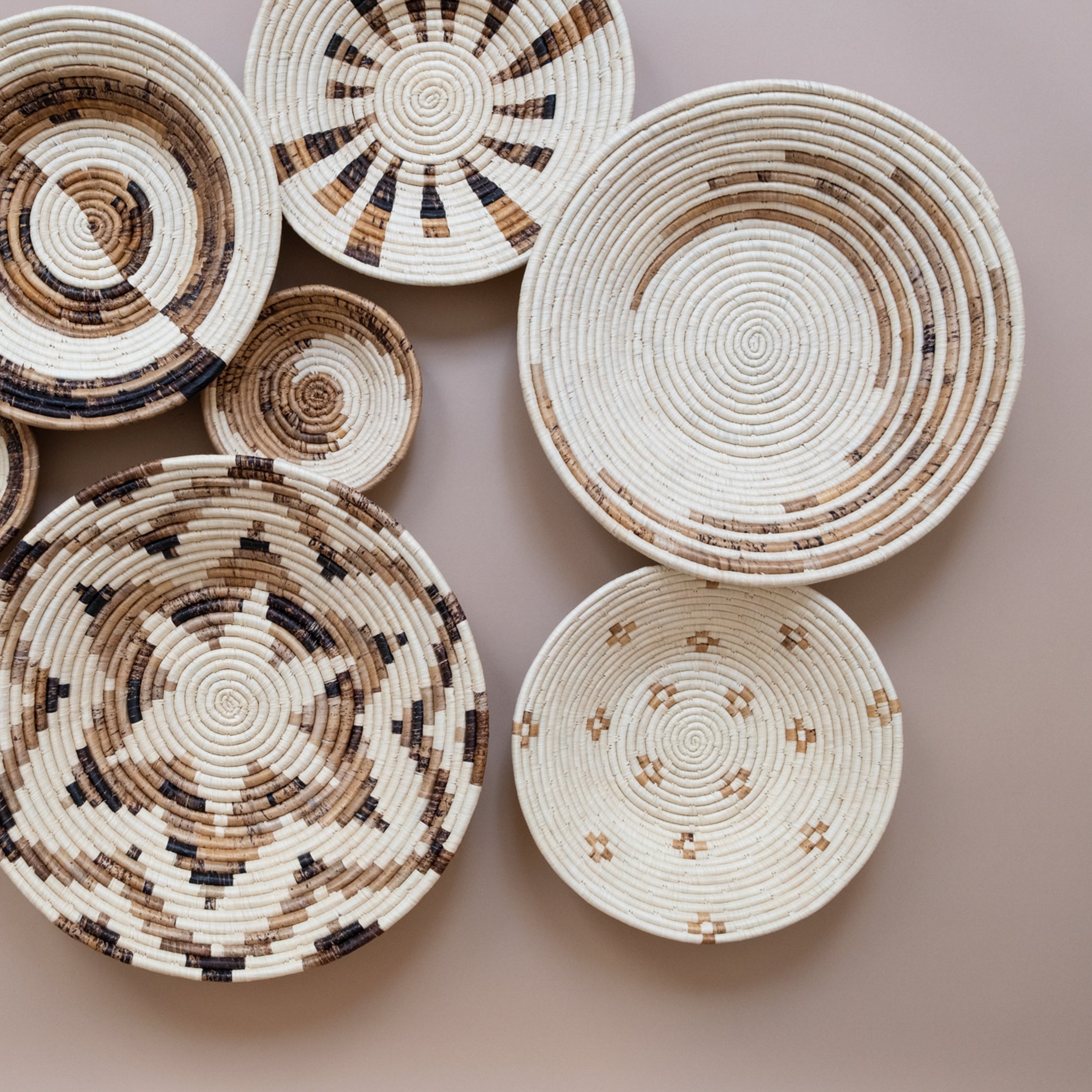 Set of woven baskets with circular patterns on a beige background