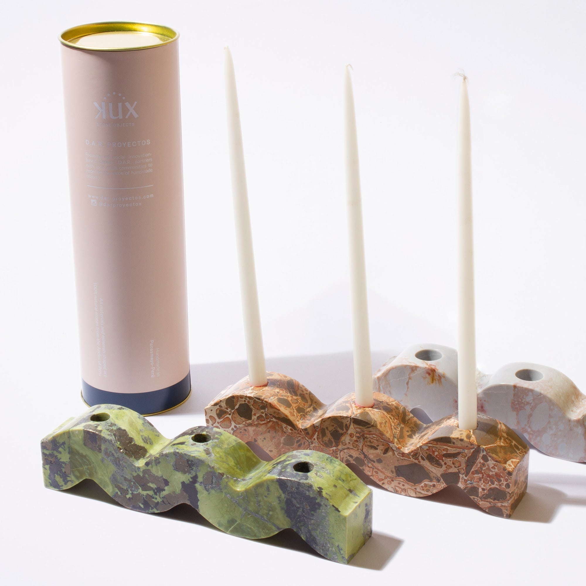 Decorative candle holders with candles and a cylindrical product on a white background