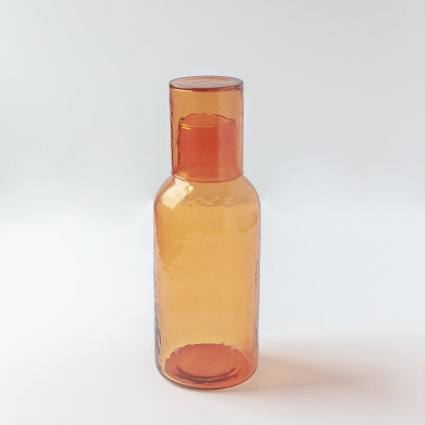 Amber glass carafe with lid on a white background