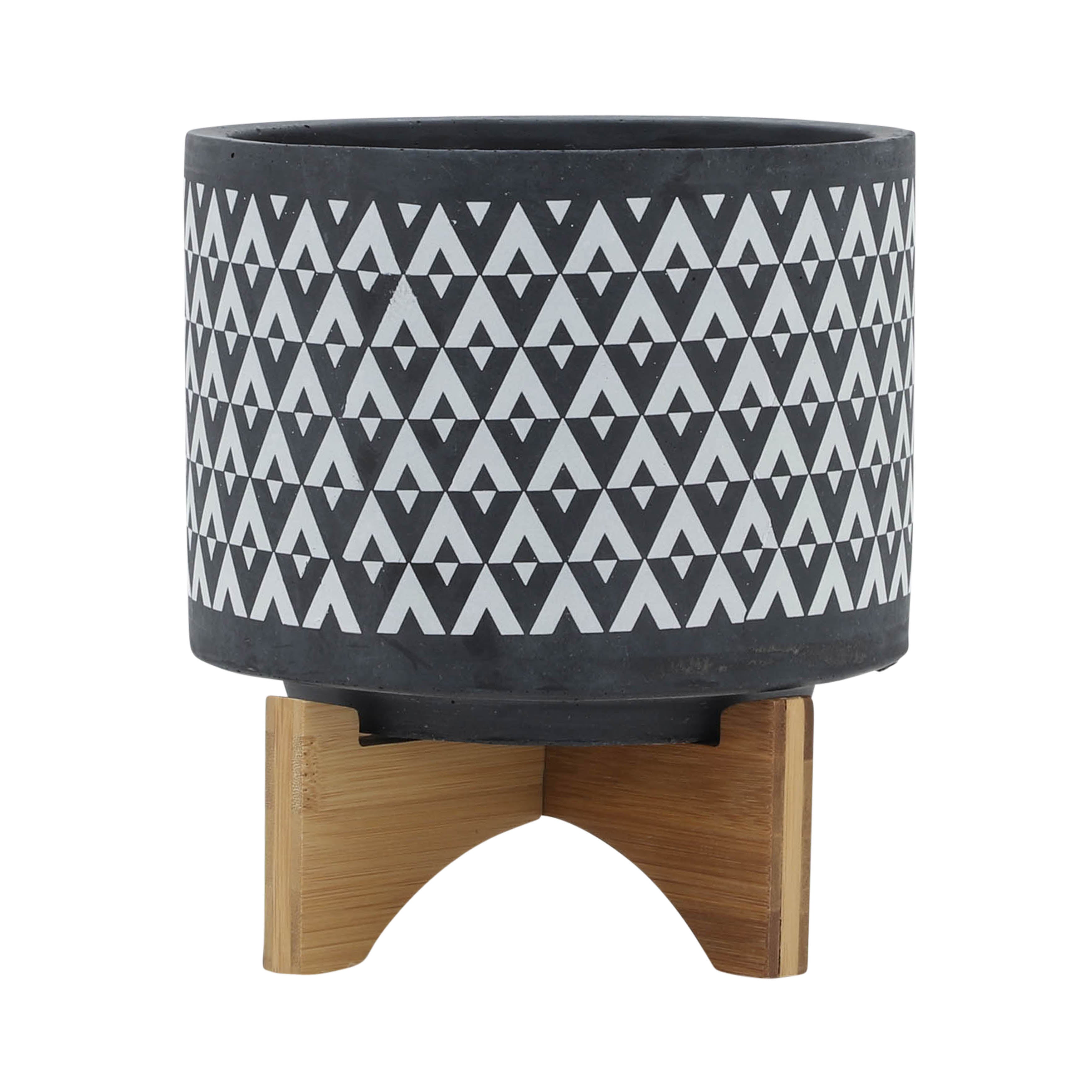 Black patterned planter with wooden base on a white background