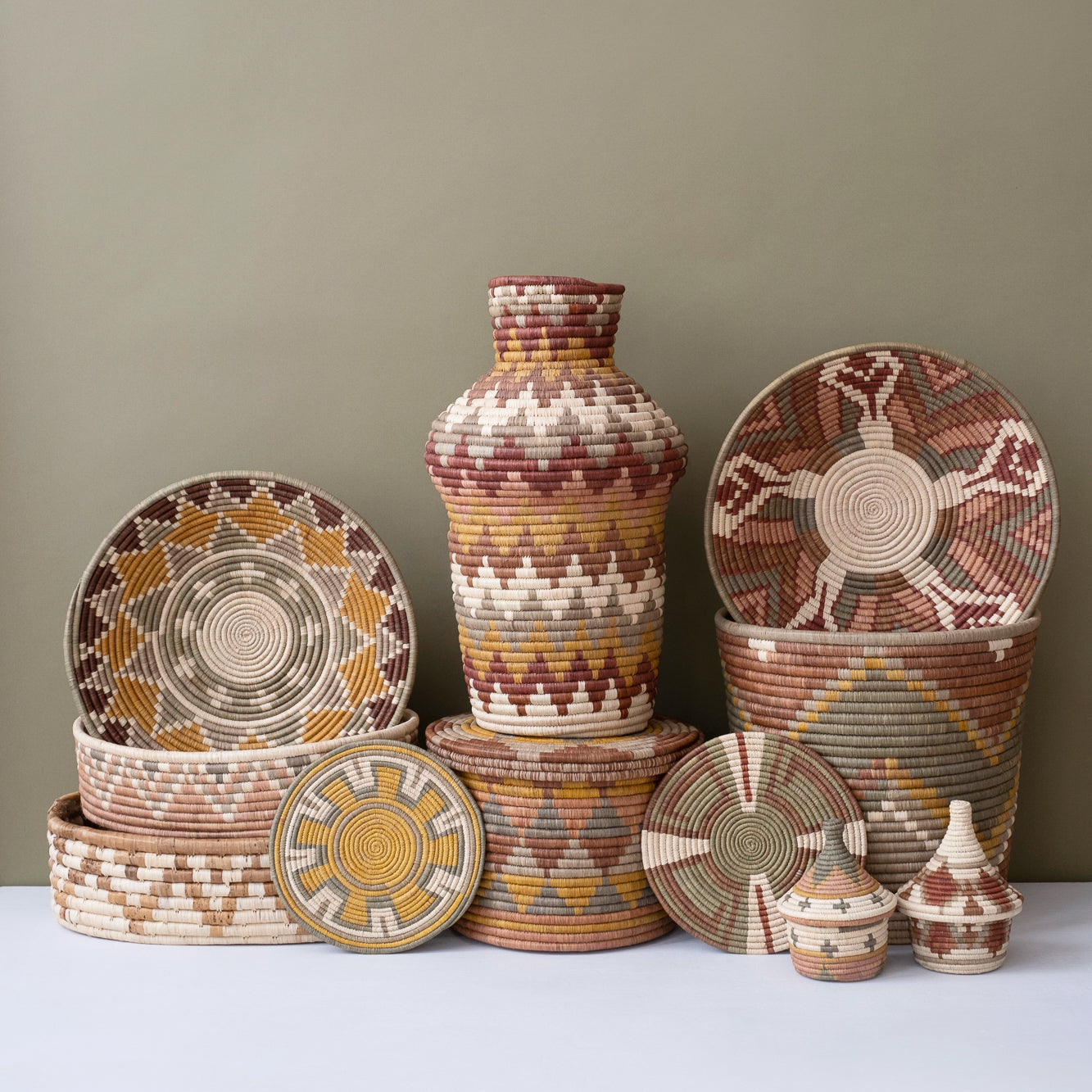 Collection of woven baskets and vases with geometric patterns on a neutral background