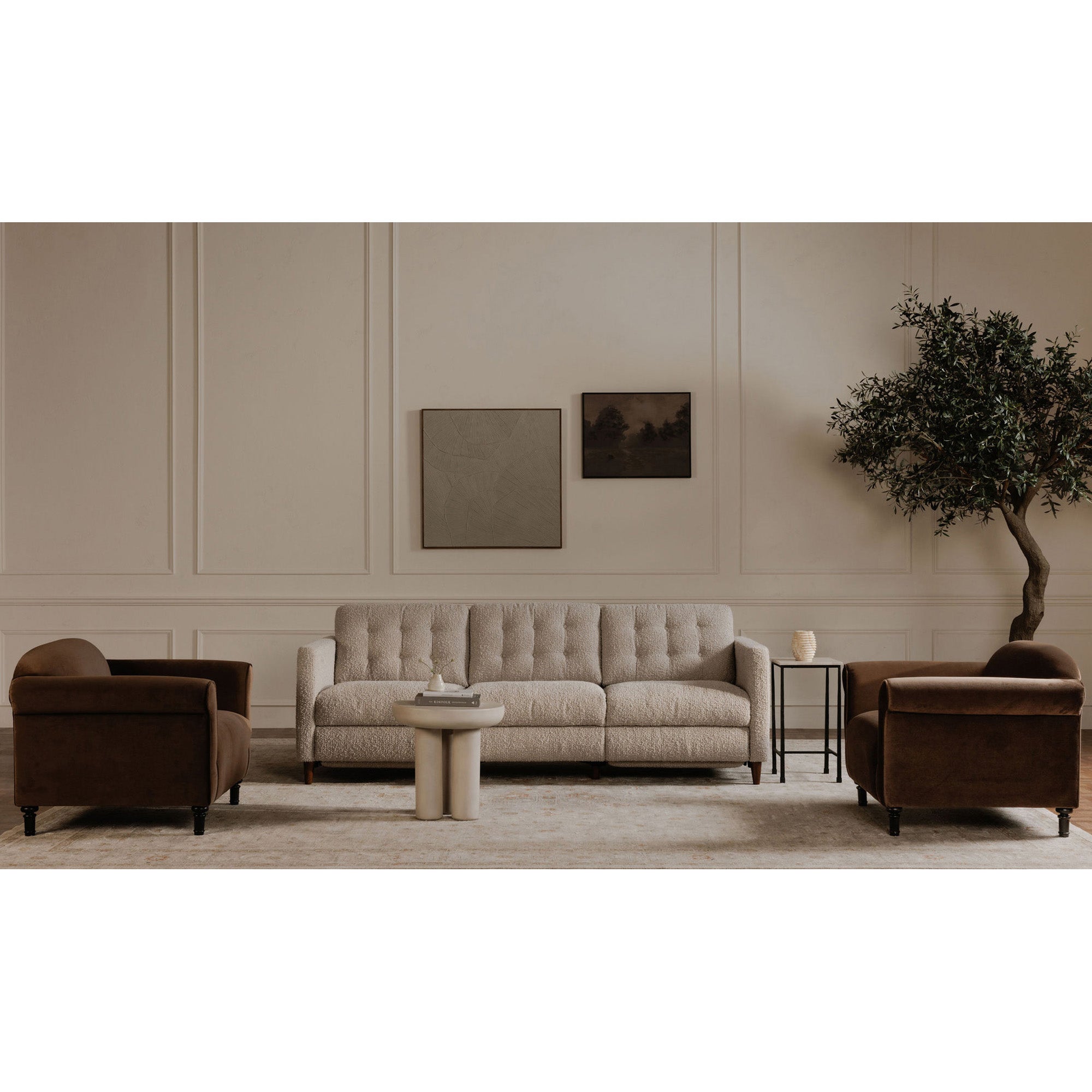 Living room with beige sofa, brown armchairs, and a tree in the corner.