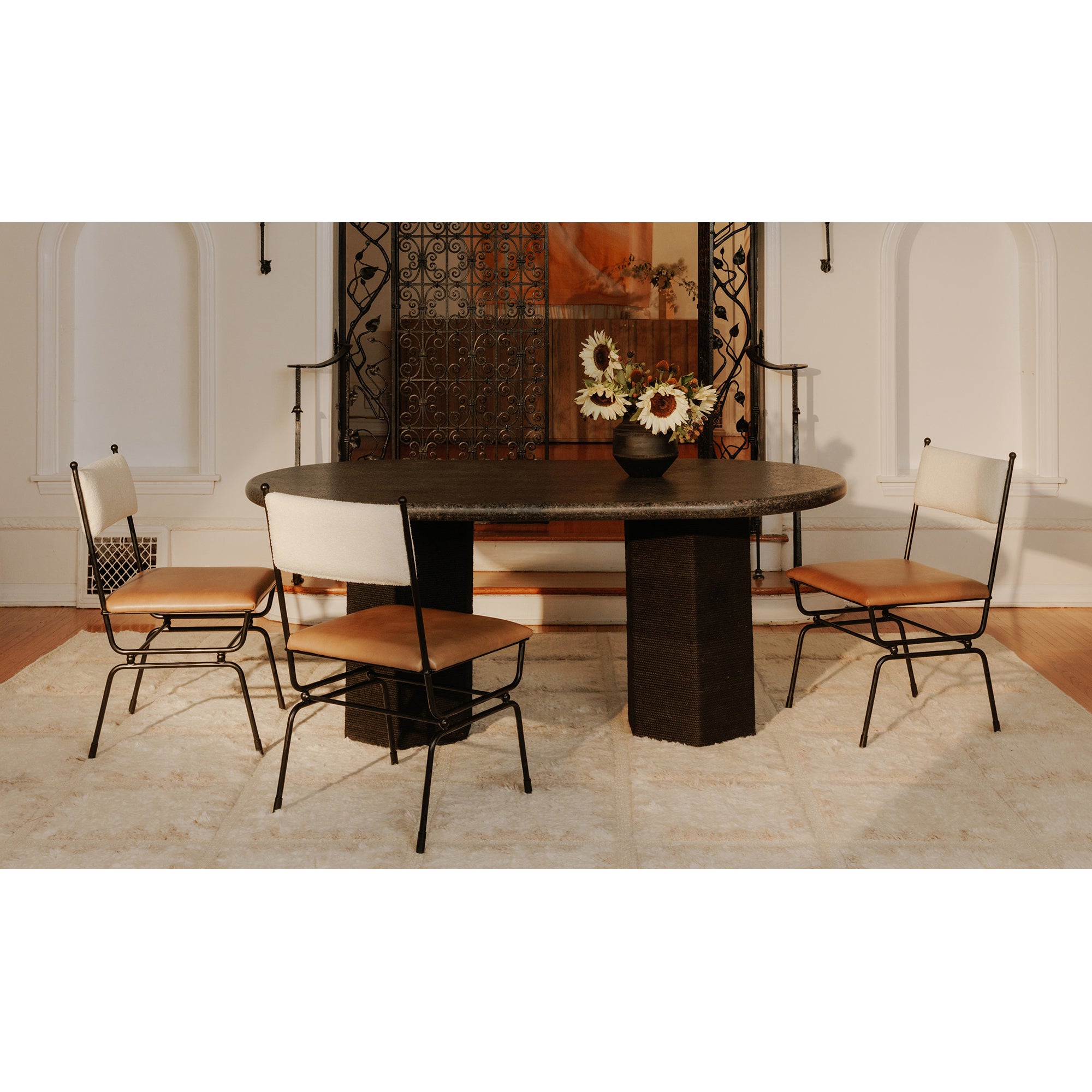 Dining table with chairs in a room with a decorative wall.