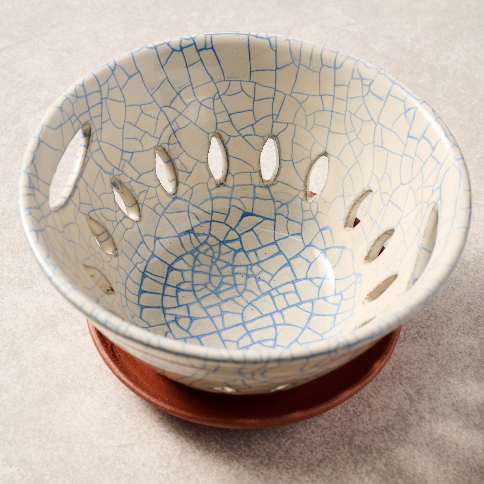 Ceramic berry bowl with cracked glaze design on a beige background