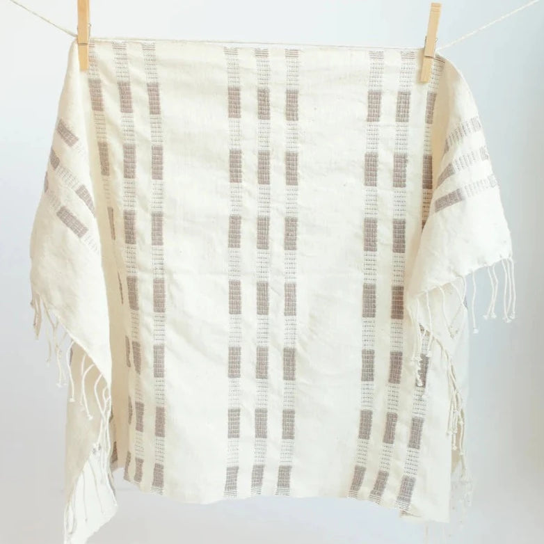 Textured cotton towel with a pattern draped over a white surface