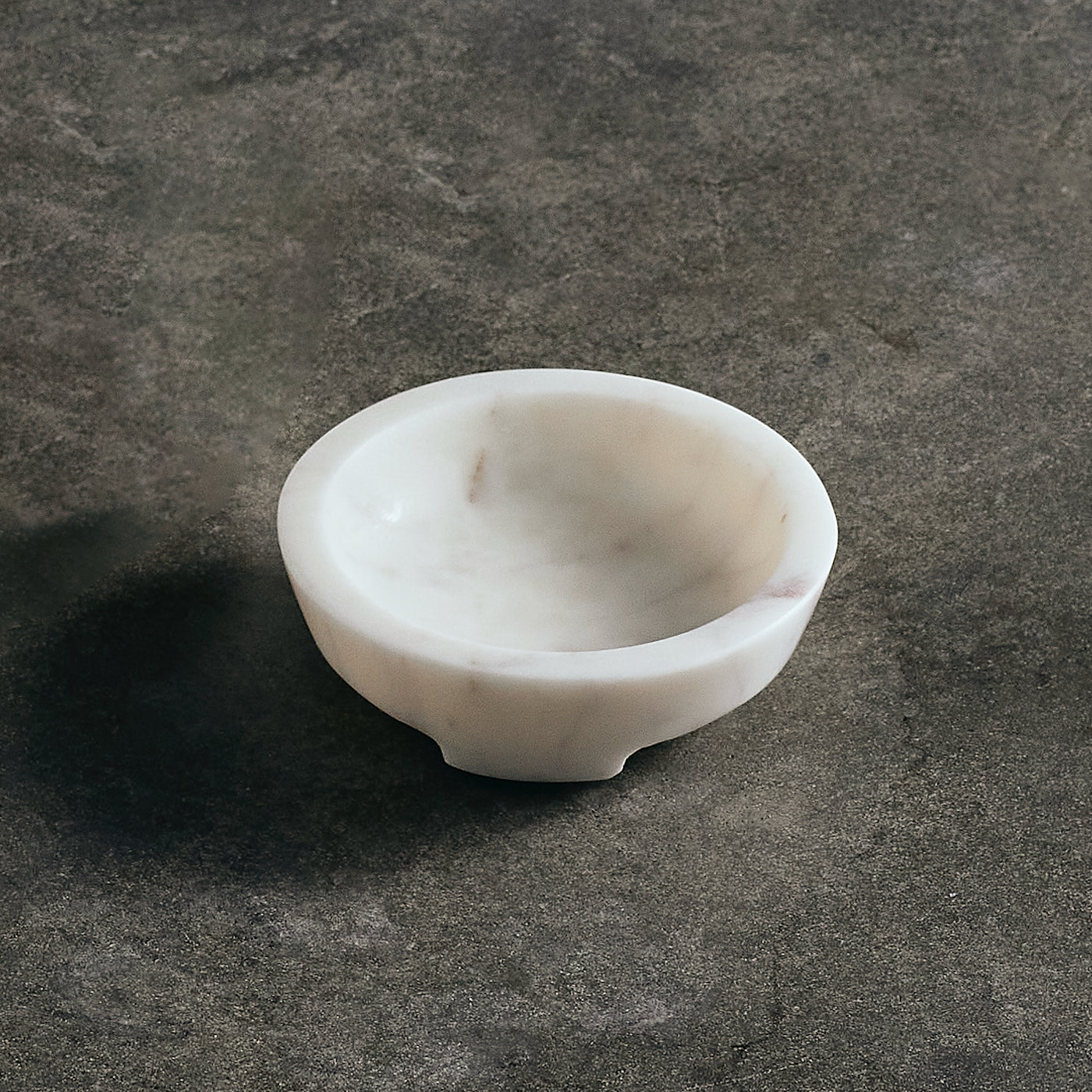 White marble bowl on a dark stone surface