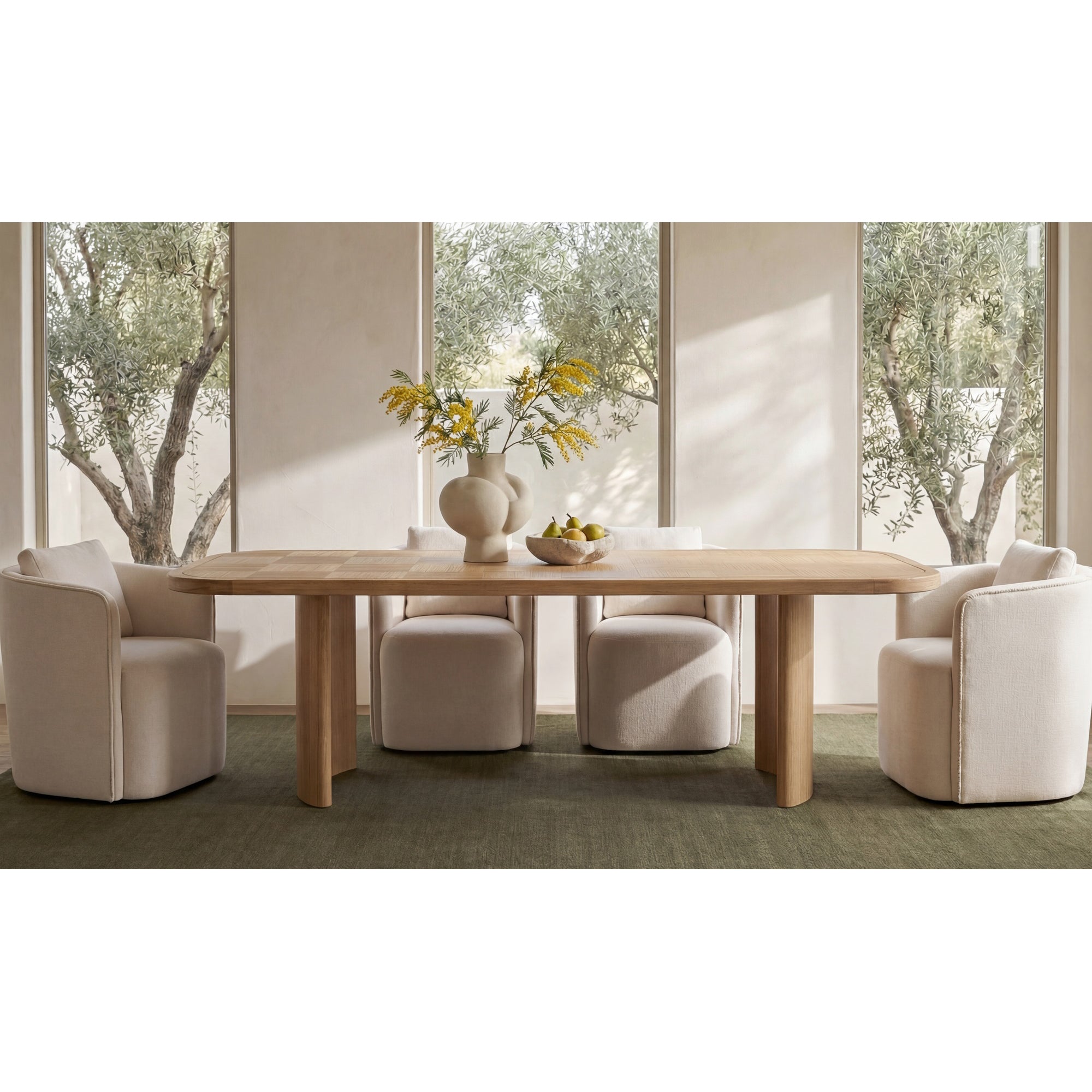 Dining room with wooden table and chairs in a bright room with large windows.