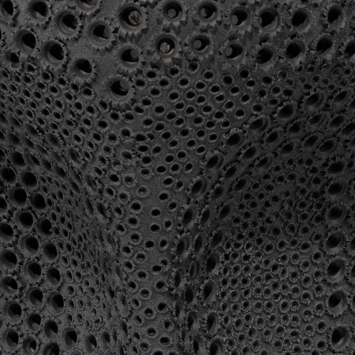 Close-up of black textured material with circular holes