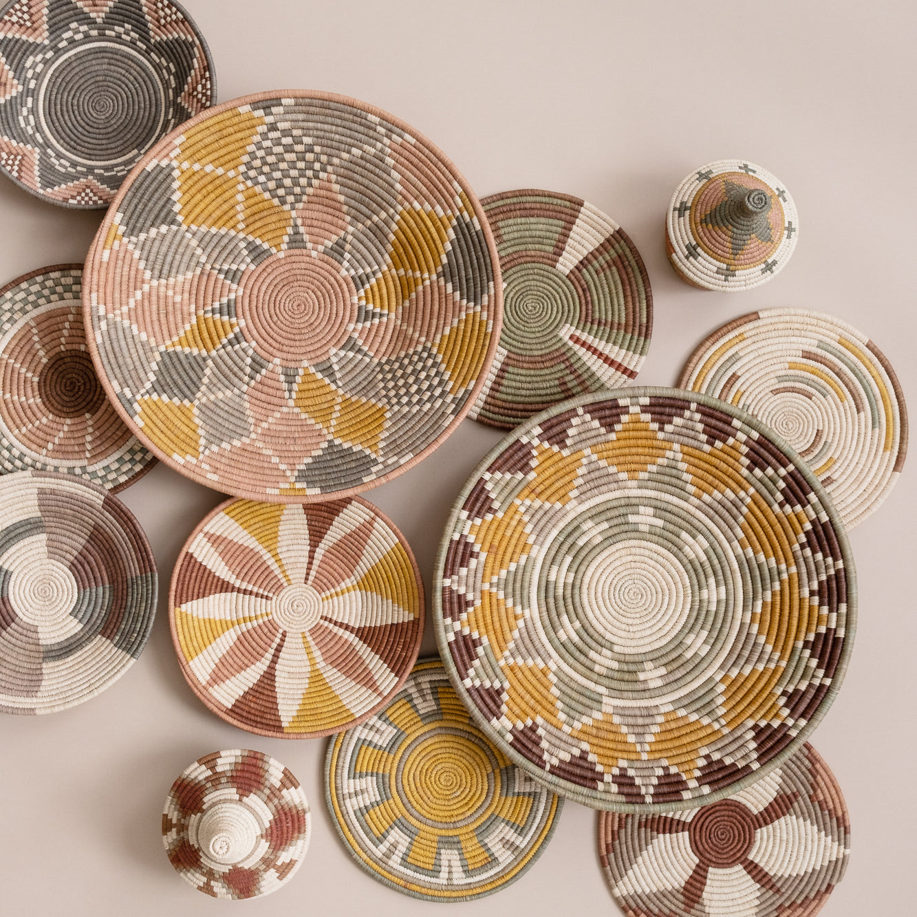 Collection of handwoven baskets with geometric patterns on a beige background