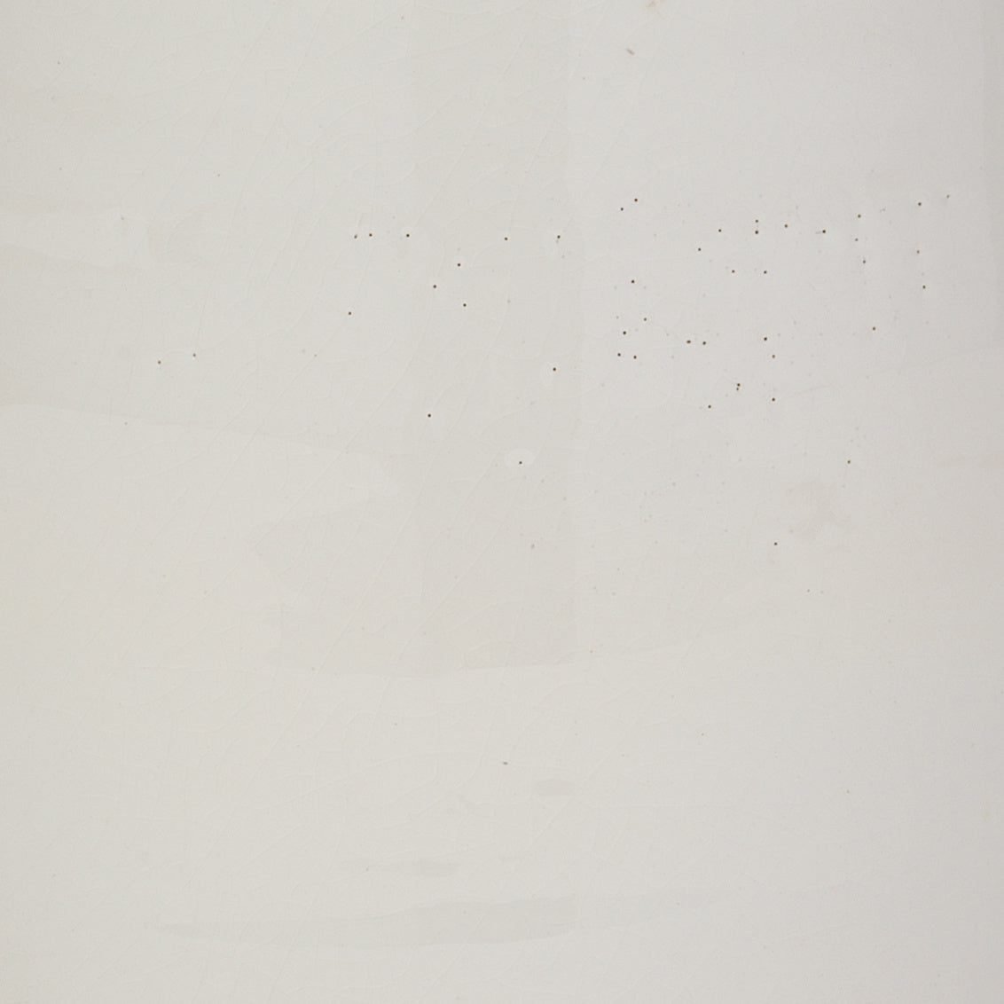 Table lamp with a white base with decorative rings and beige lampshade on a white background