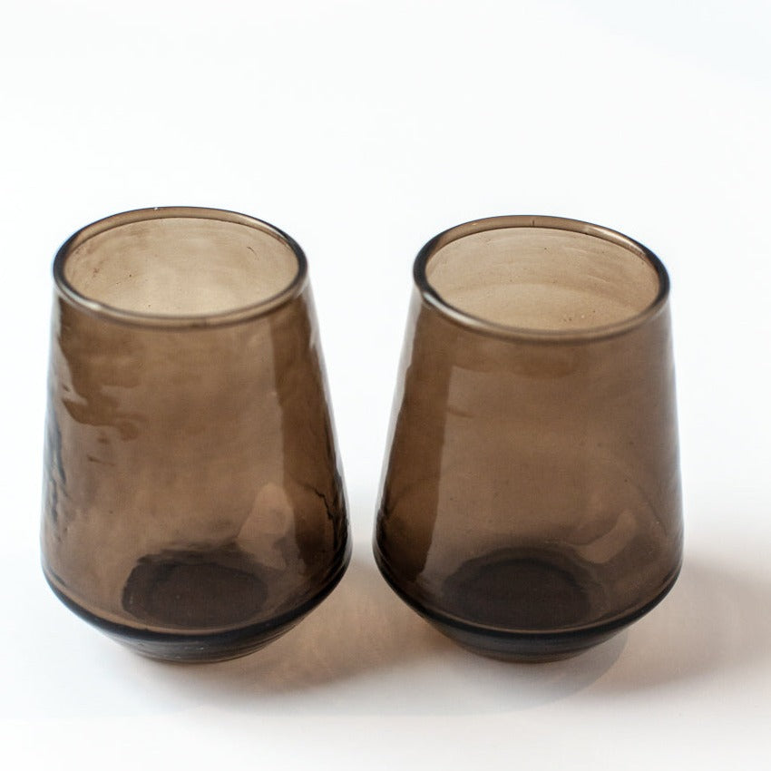 Two brown glass tumblers on a white background